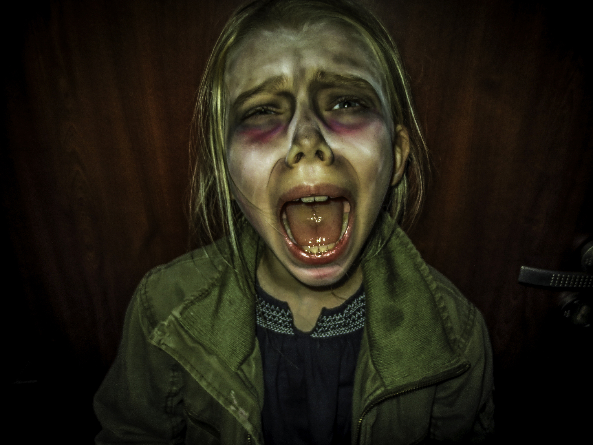 portrait of a small girl child with a halloween make  up she scr