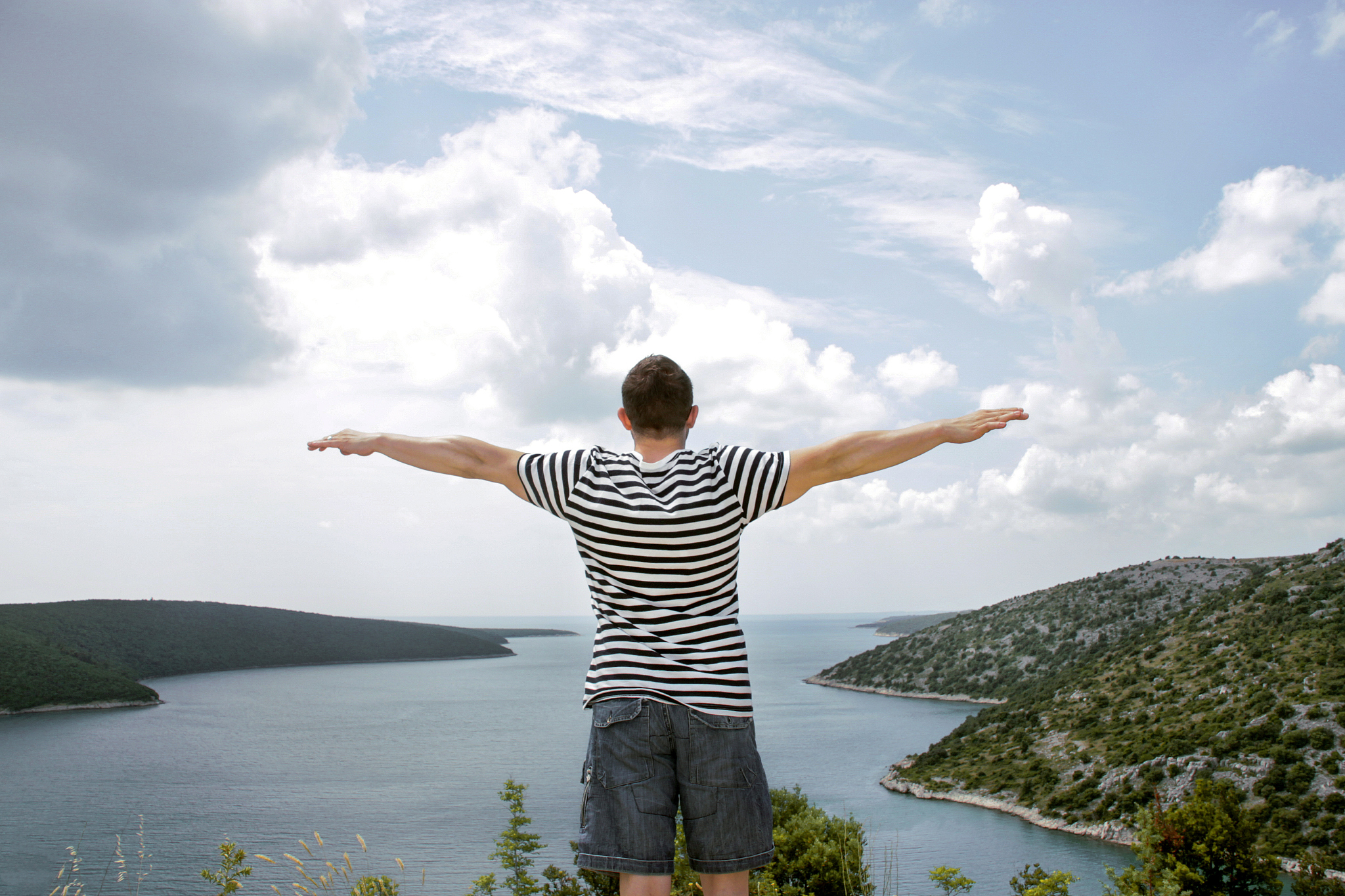 man who spreads his hands towards the sea