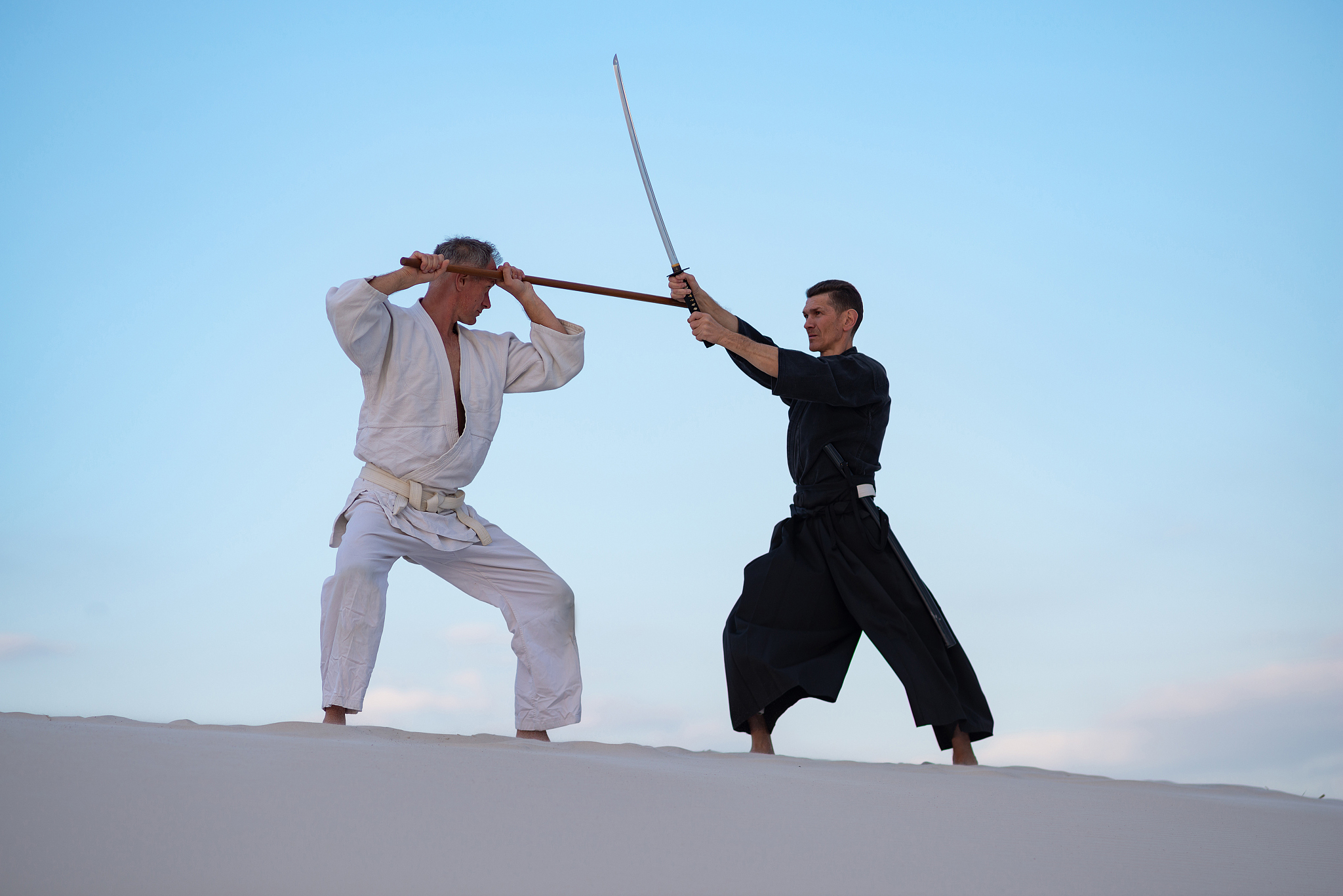 two focused man, in japanese clothes,are practicing martial arts