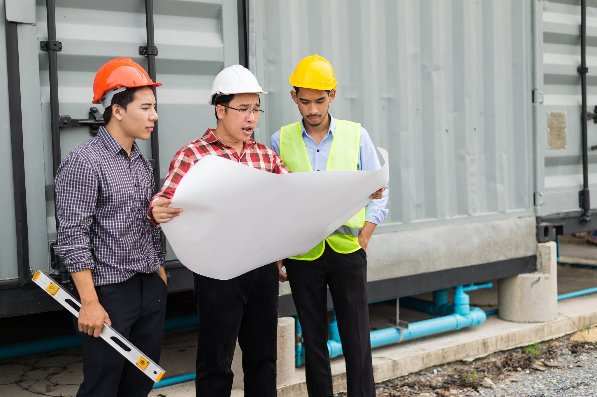 engineer and construction team wearing safety helmet and bluepri
