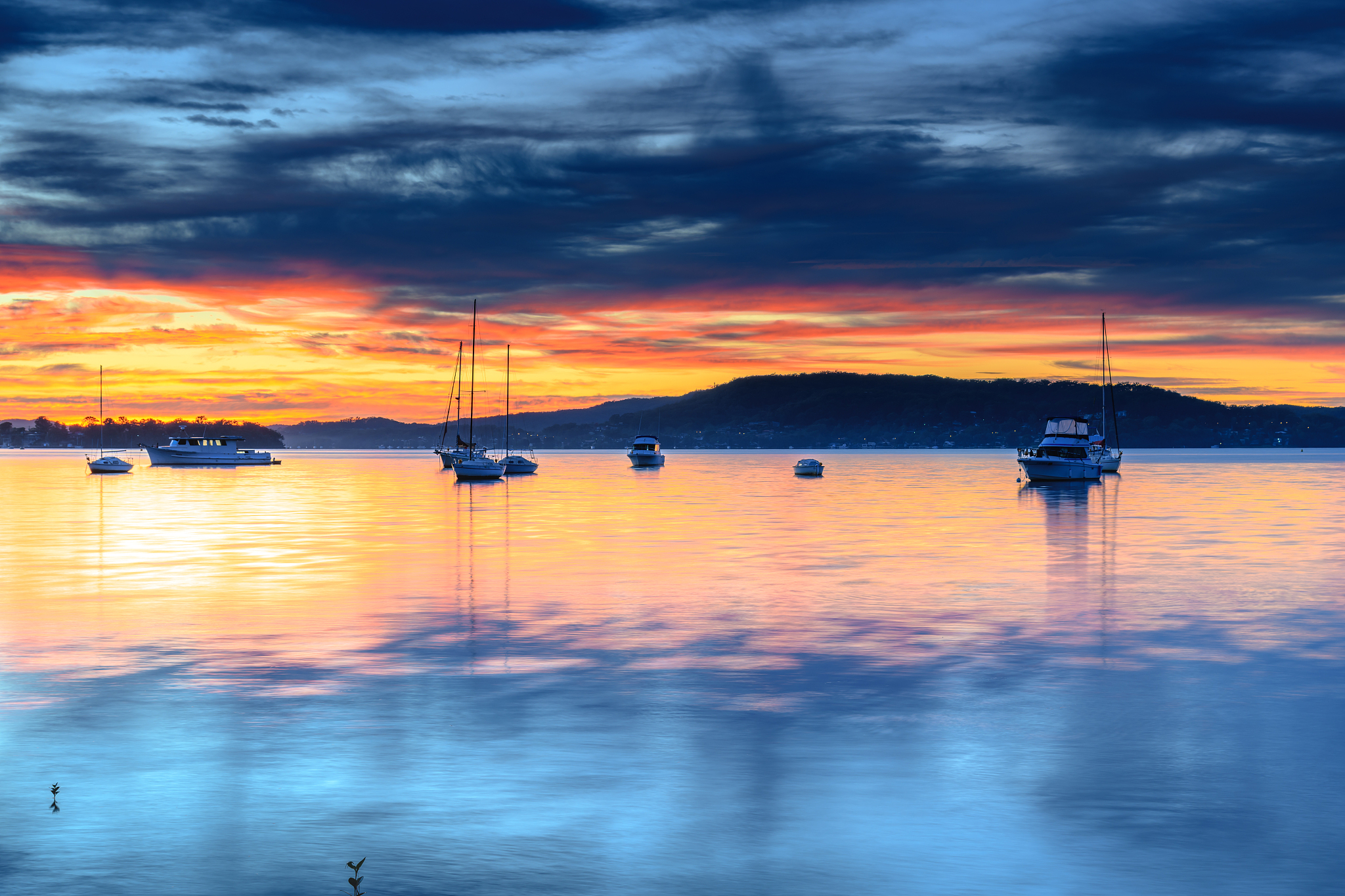 sunrise and high cloud over the bay with boats