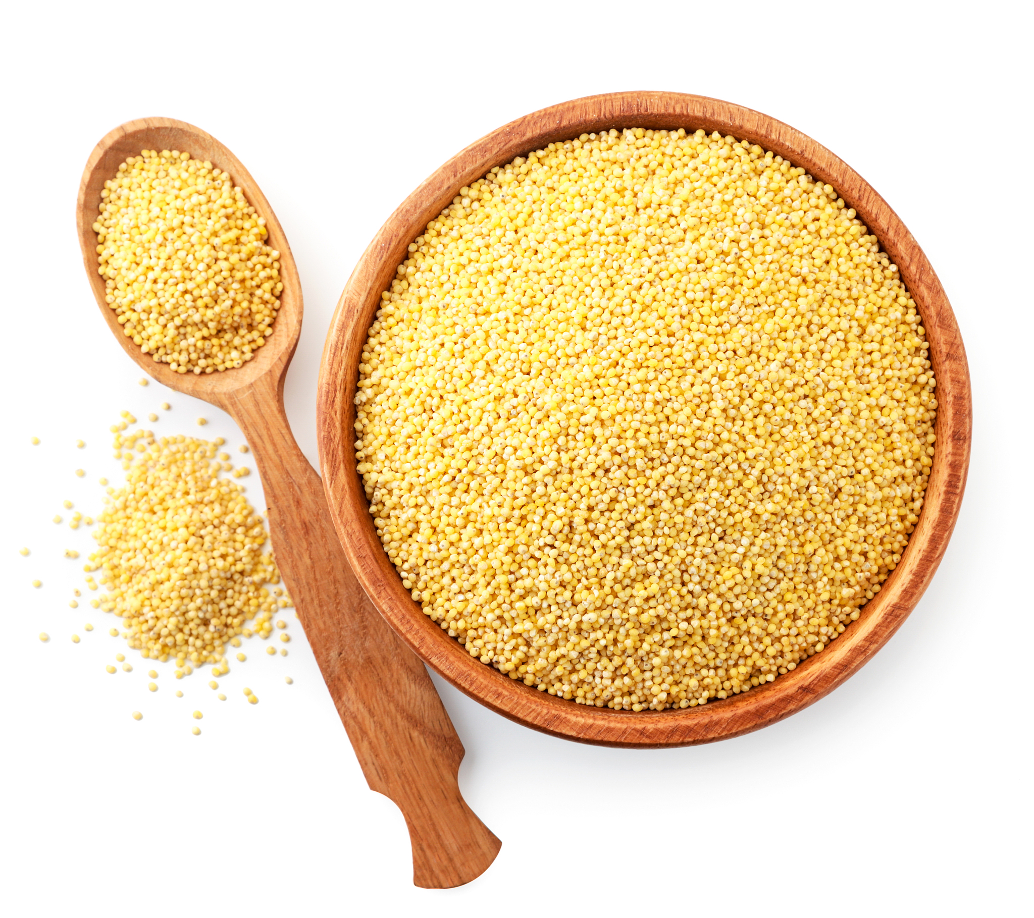 millet in a wooden spoon and plate on a white background, isolat