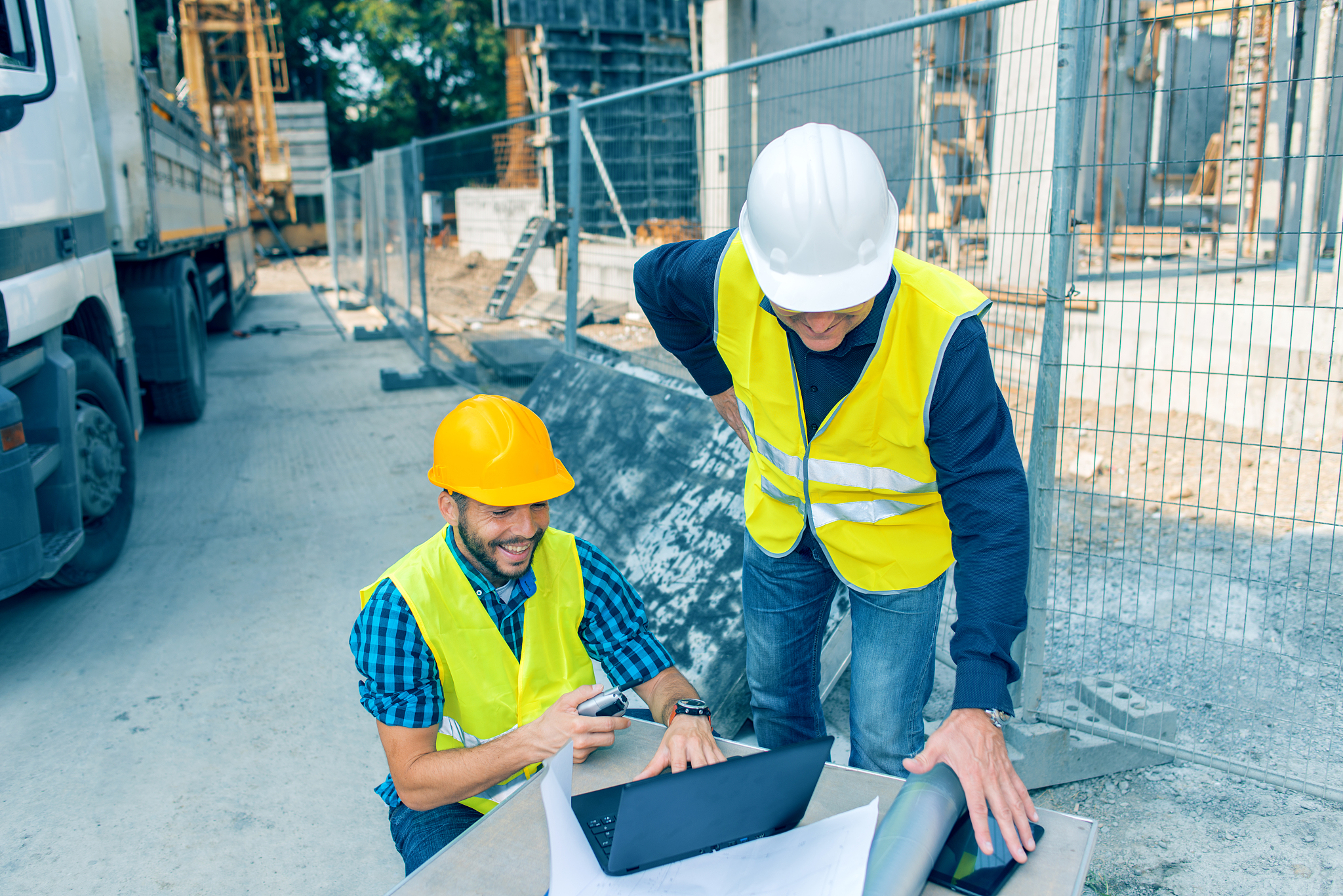 engineer and architect looking at blueprints on construction sit