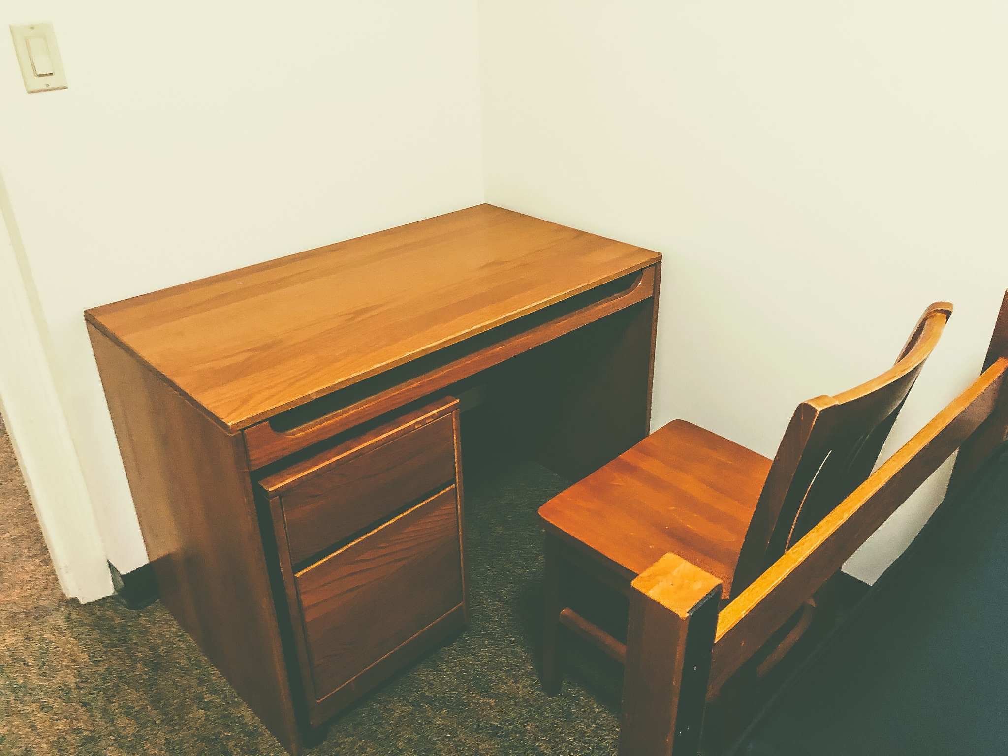 basic student desk in nondescript undecorated white box dorm roo