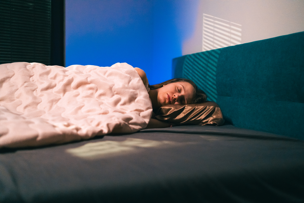 宁静的夜晚睡眠——女人在舒适卧室的丝绸枕头上休息