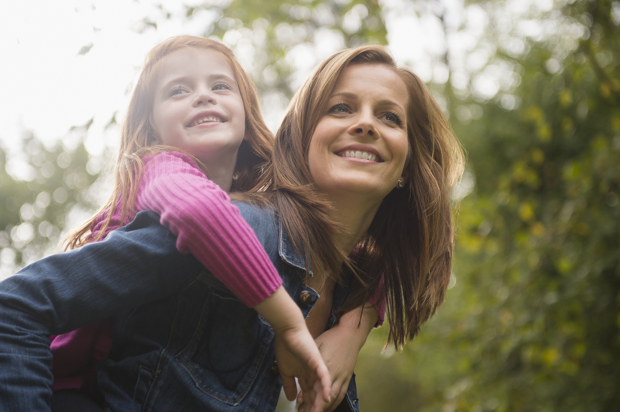 mother giving daughter piggy back ride
