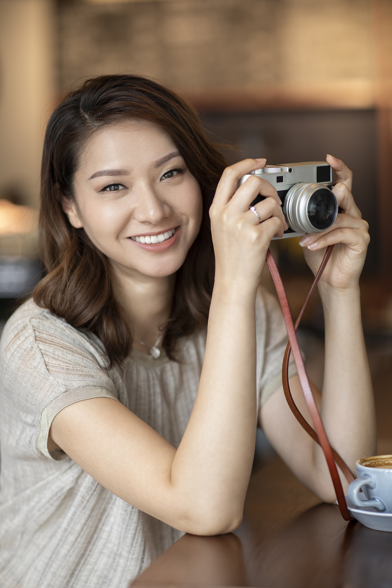 优雅女士在咖啡店使用相机