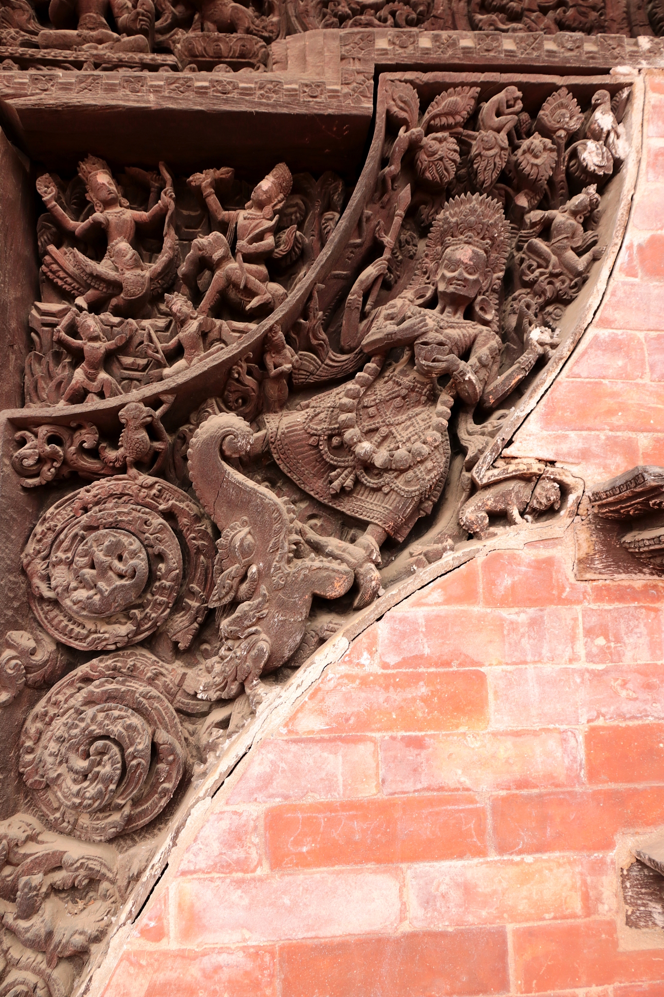 carved wooden window in brick wall