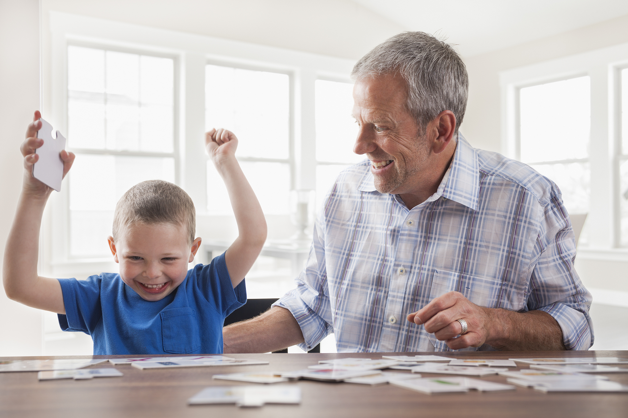 caucasian father and son playing cards