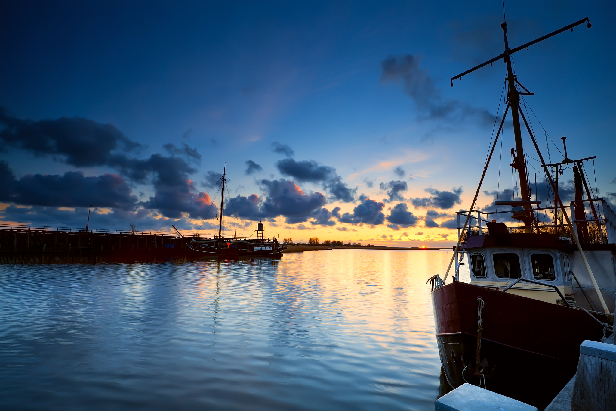 fishing boats on river at sunset