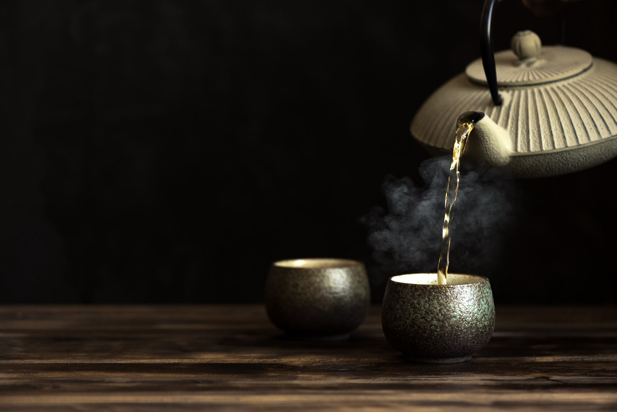 teapot and tea cups with steaming tea