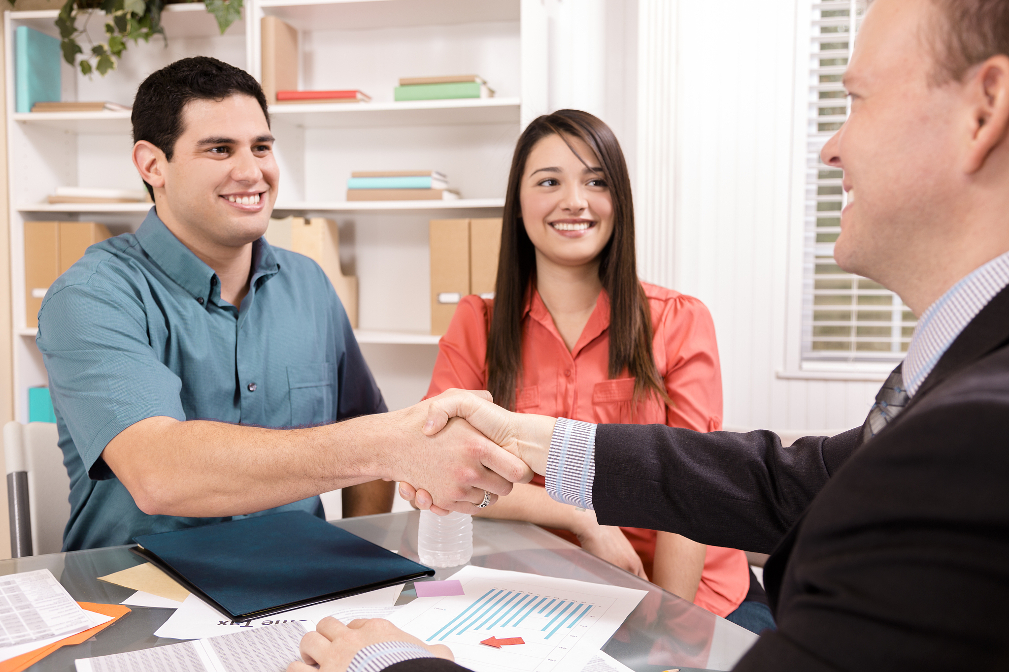 business: latin couple reviews financial documents with advisor.