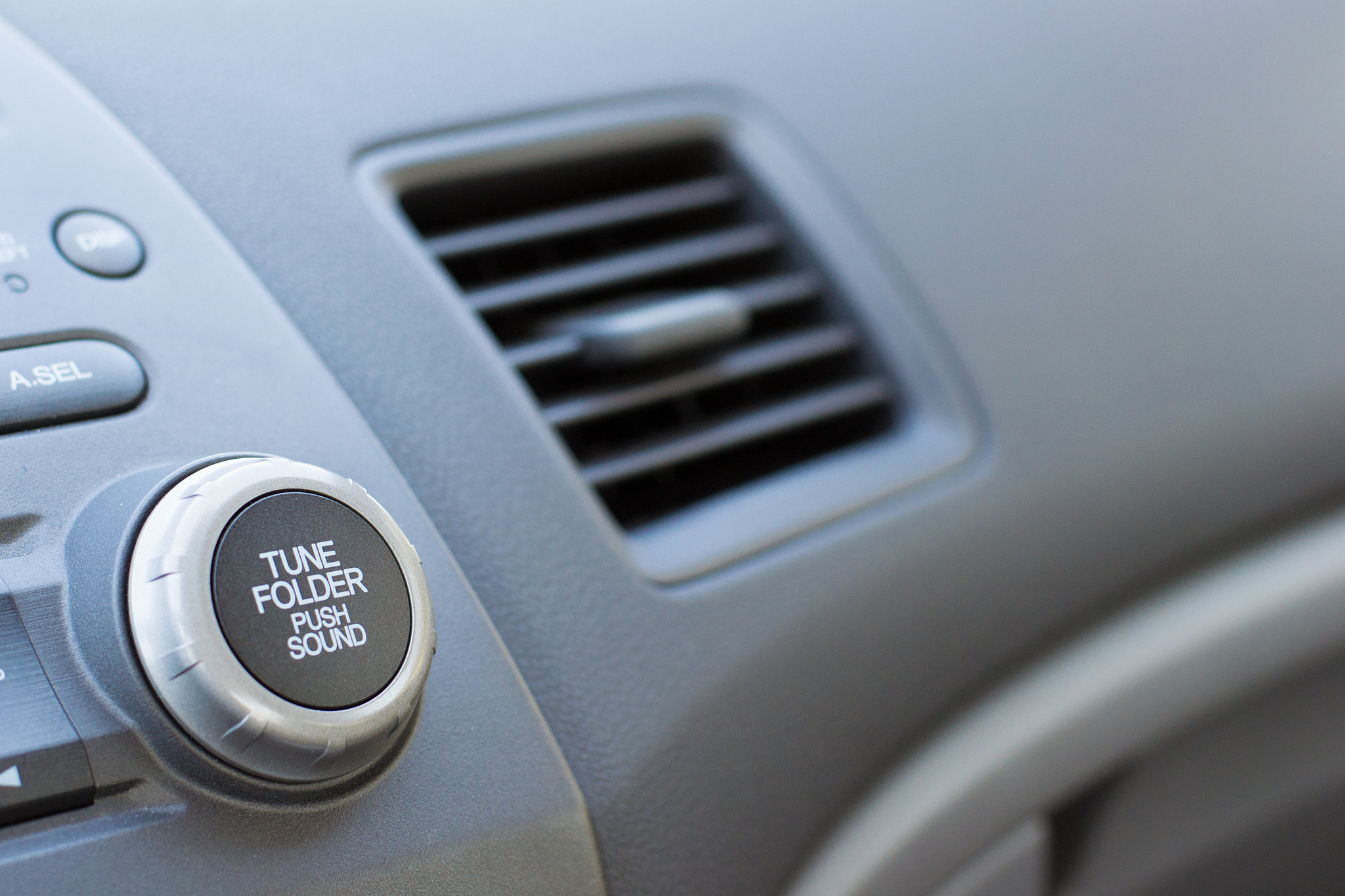 vehicle air vent opened on passenger side showing partial dashbo