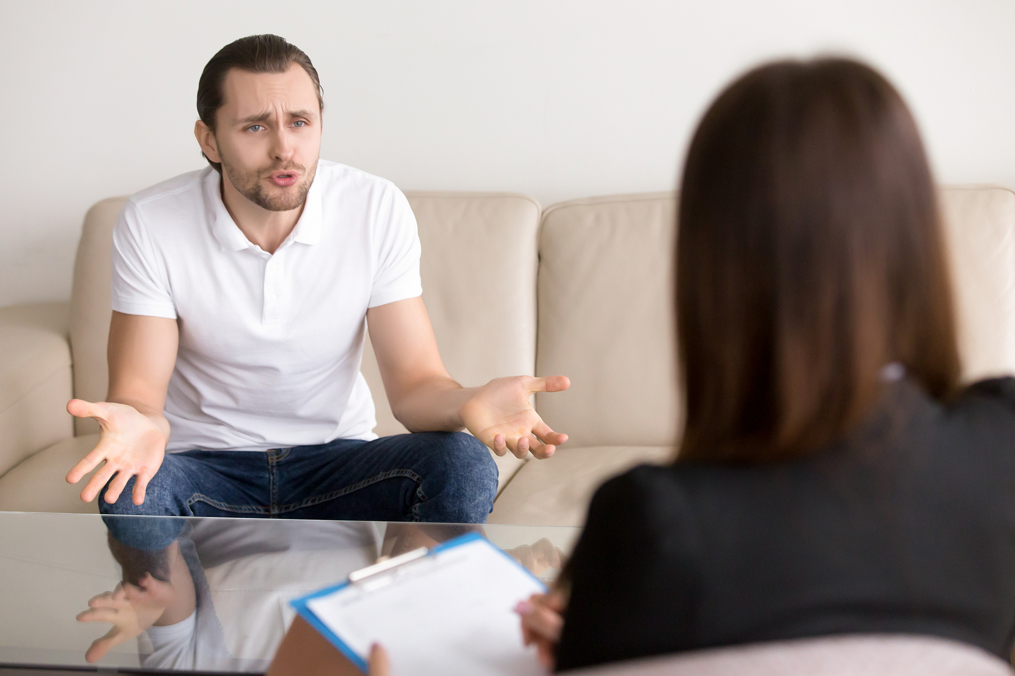 angry troubled man complaining to female psychotherapist, talkin