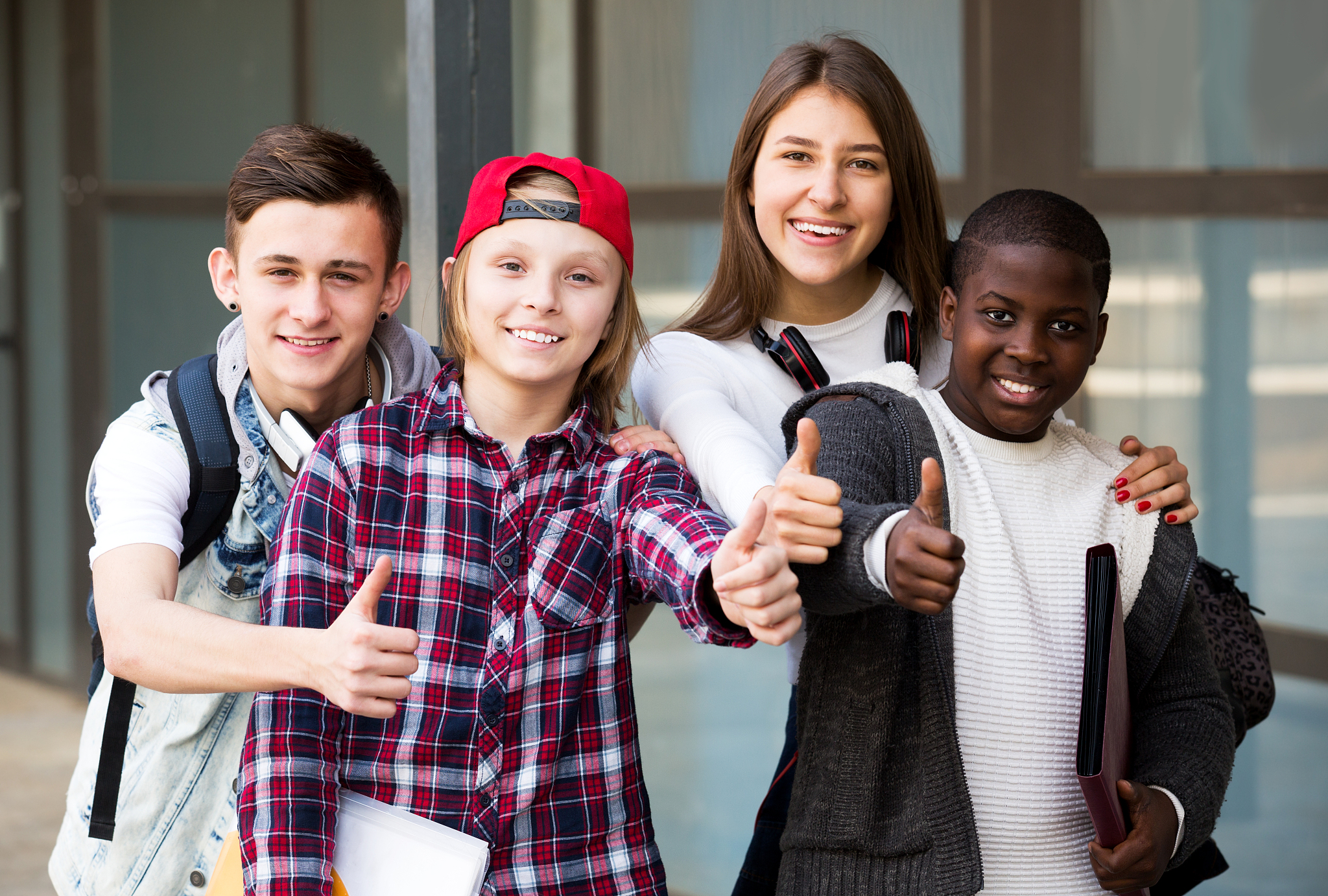 group of teens posing outside school