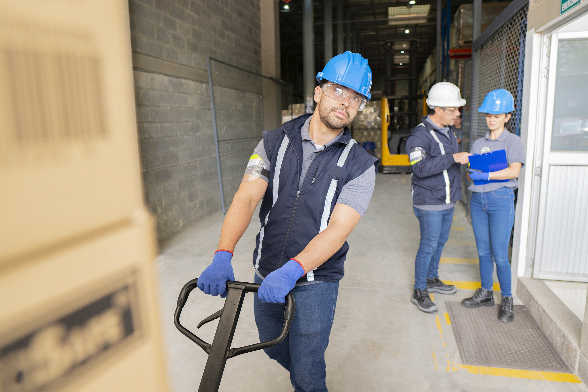 latin woman employed in a large factory talks with one of her co