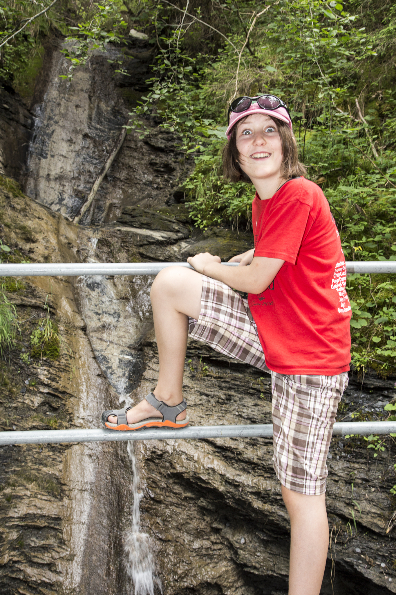child in front of waterfall