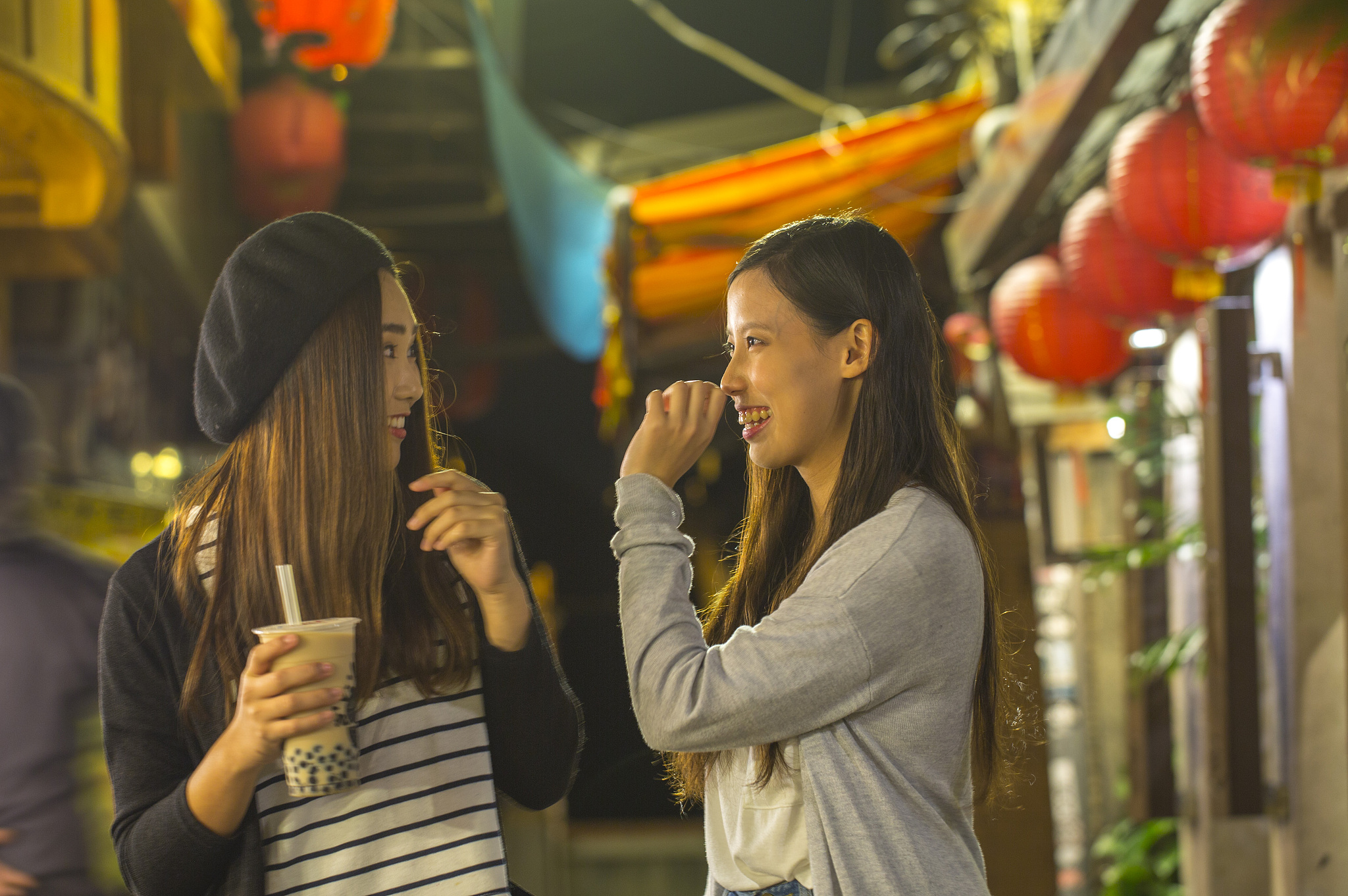 二位年轻女人在九份老街开心的聊天