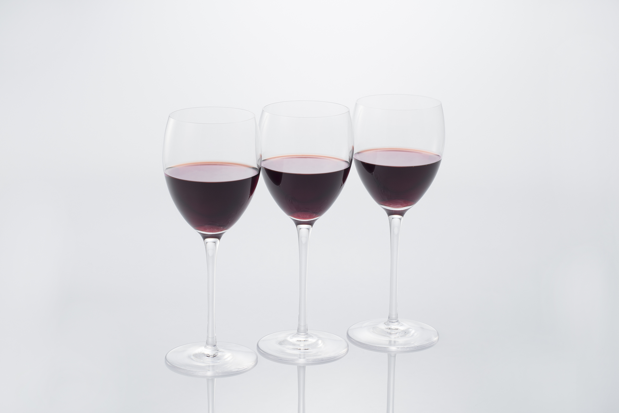 three red wines on white background.