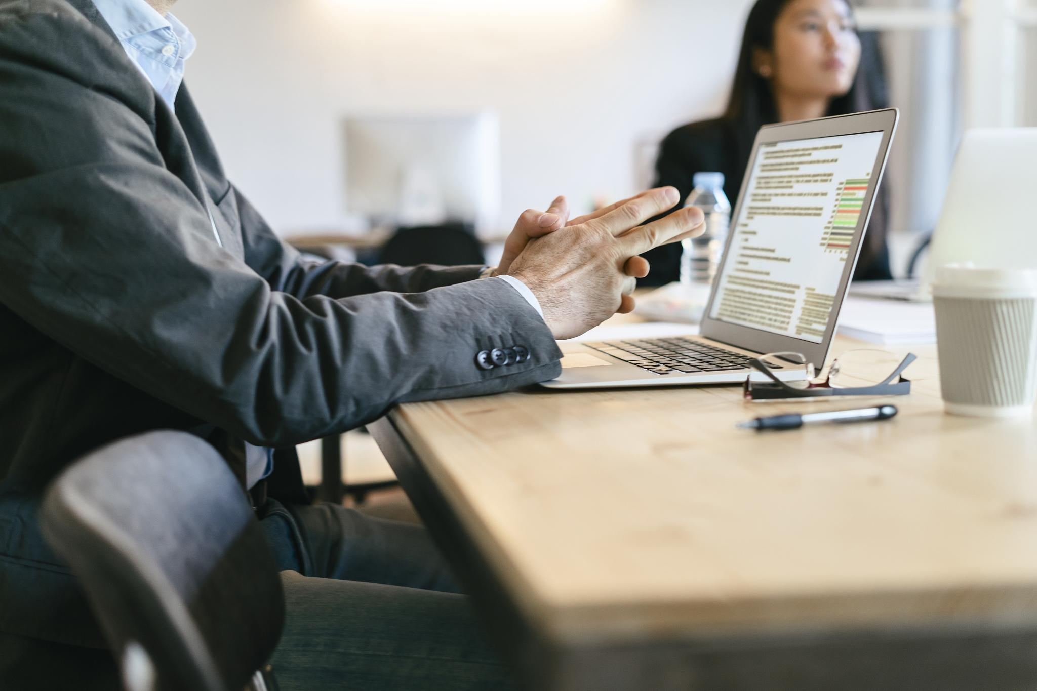 businessman sitting in meeting, using laptop