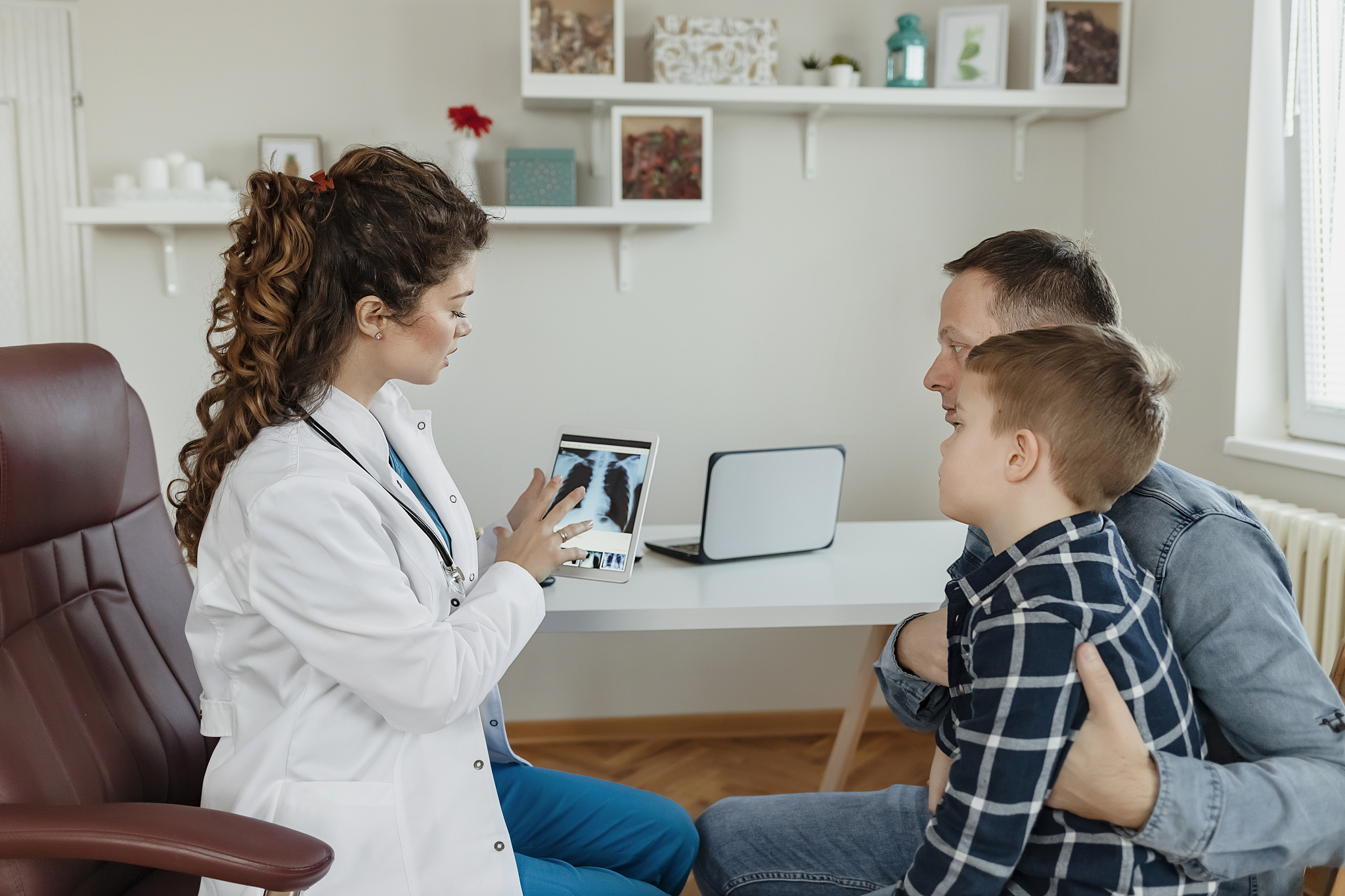 doctor showing father medical results on tablet