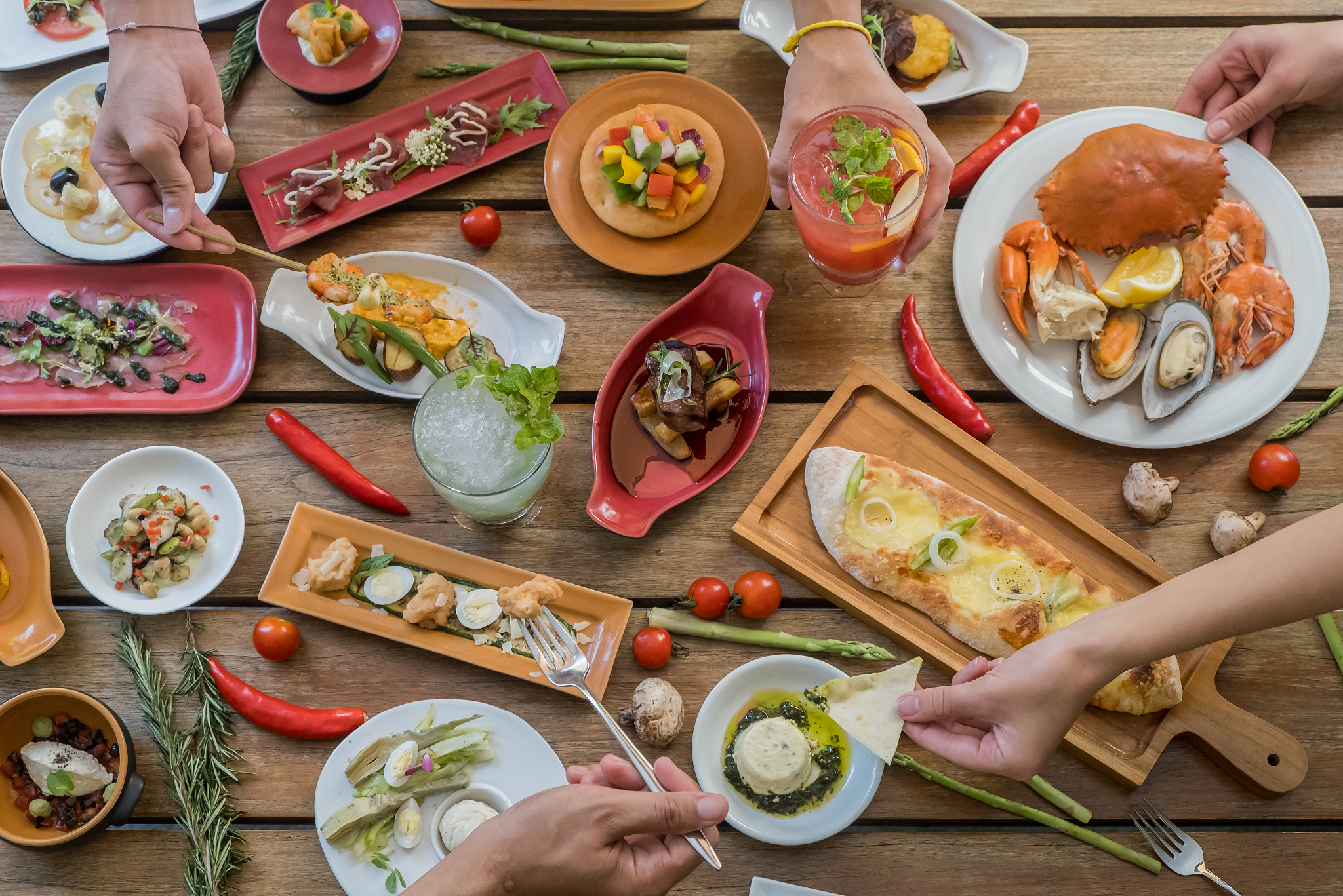 people eat meals at festive table served for party. friends eat 