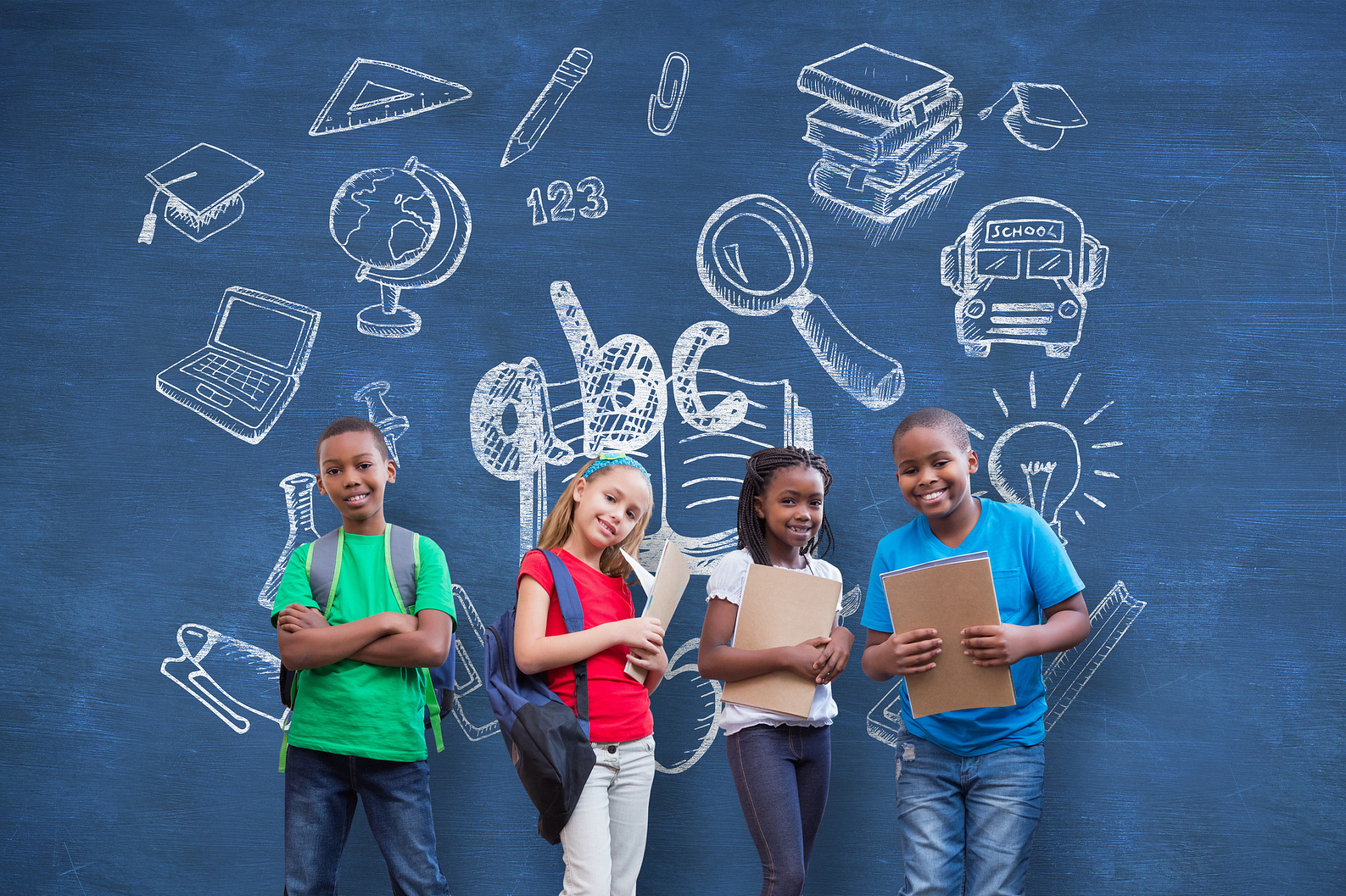 cute pupils smiling at camera against blue chalkboard with schoo
