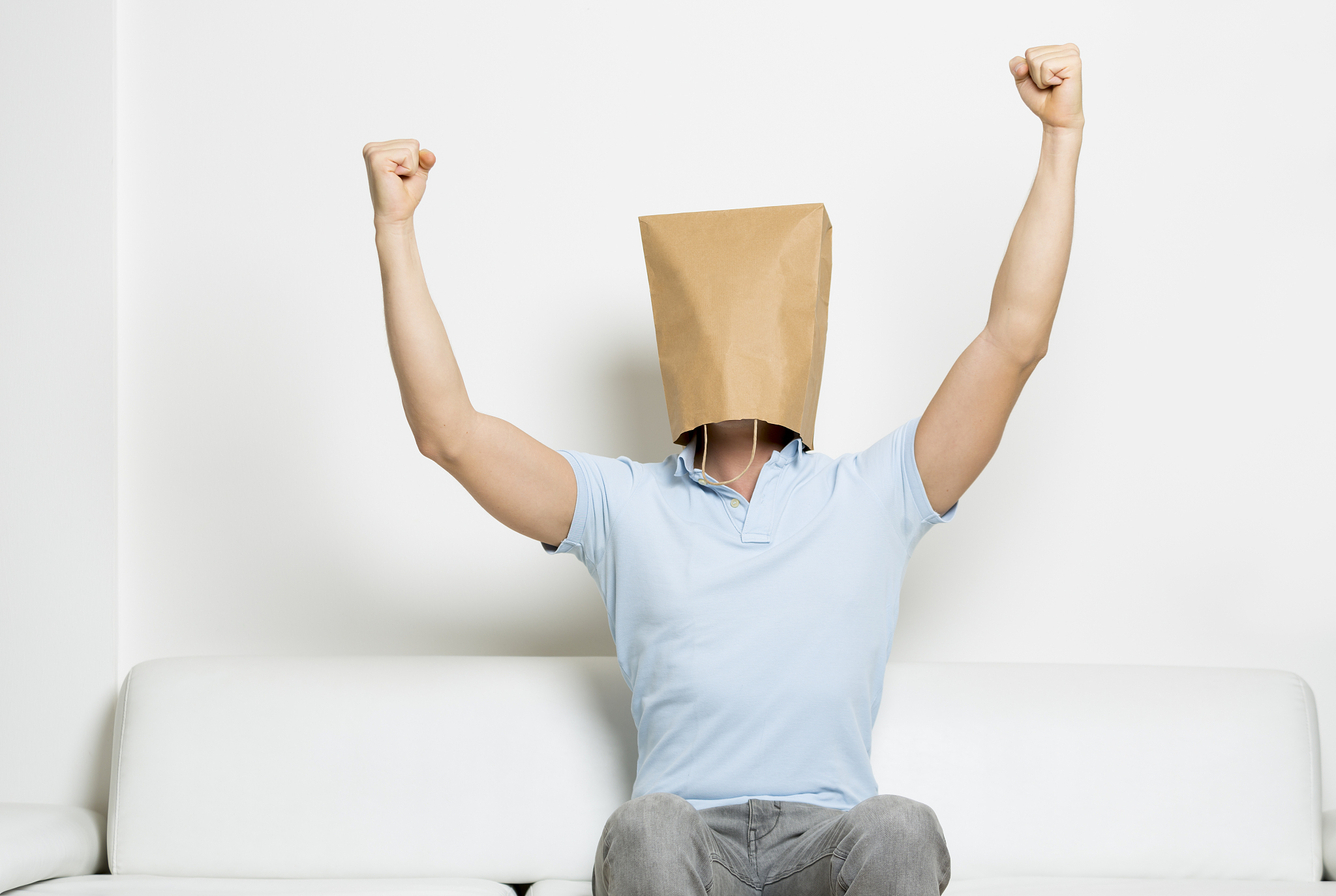 successful anonymous man with head covered, arms in the air.