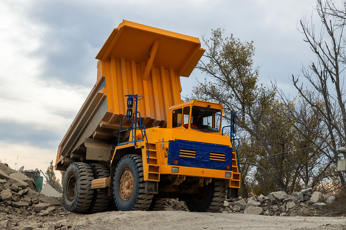 专业学术的文字内容，描述露天采矿场运输卡车的作用，包括成本，重要性。字数600个字以内。