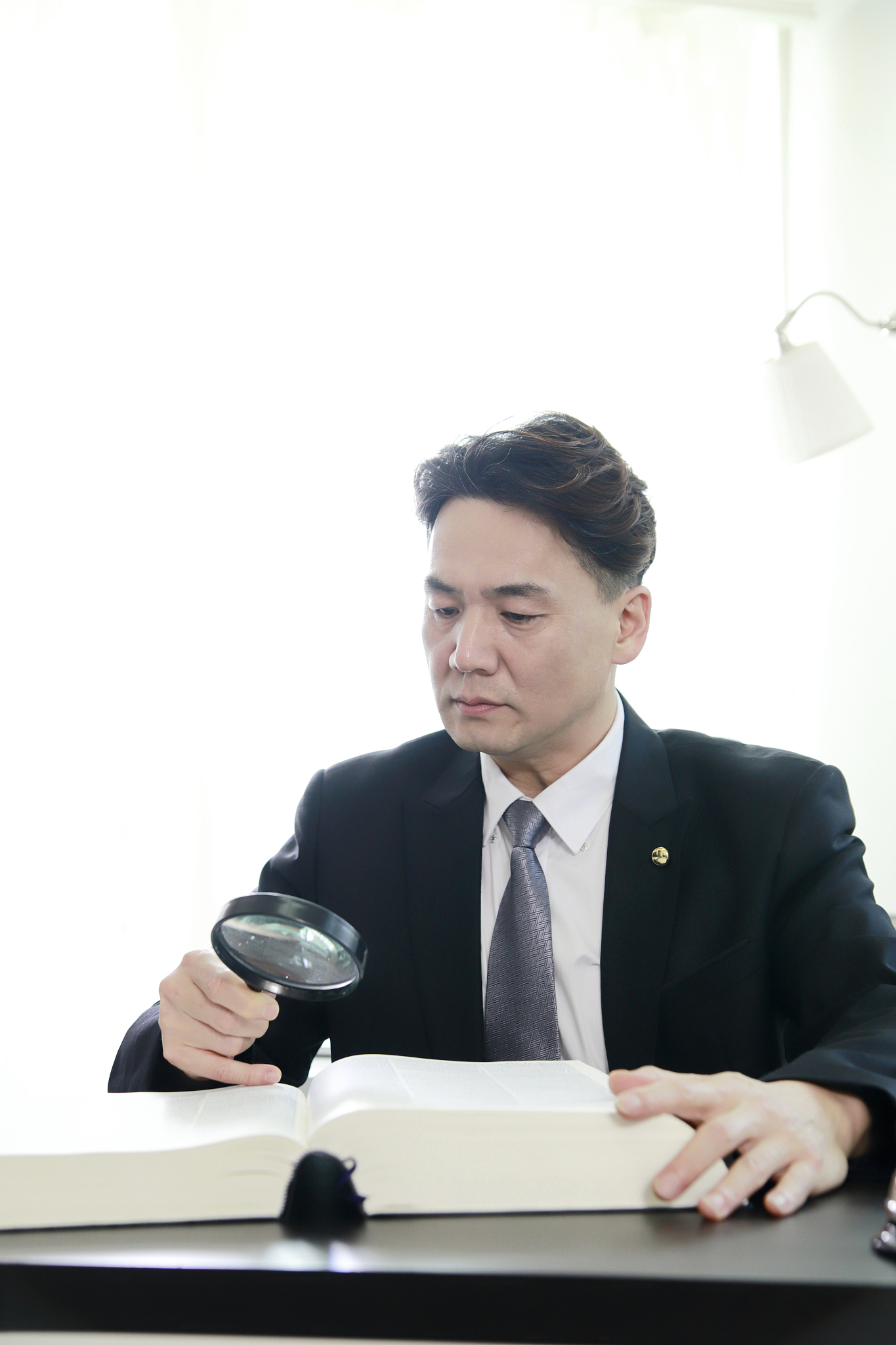 lawyer reading law book with magnifying glass