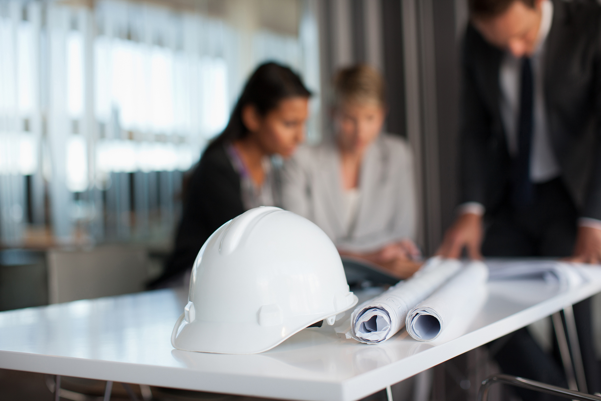 business people reviewing blueprints in conference room