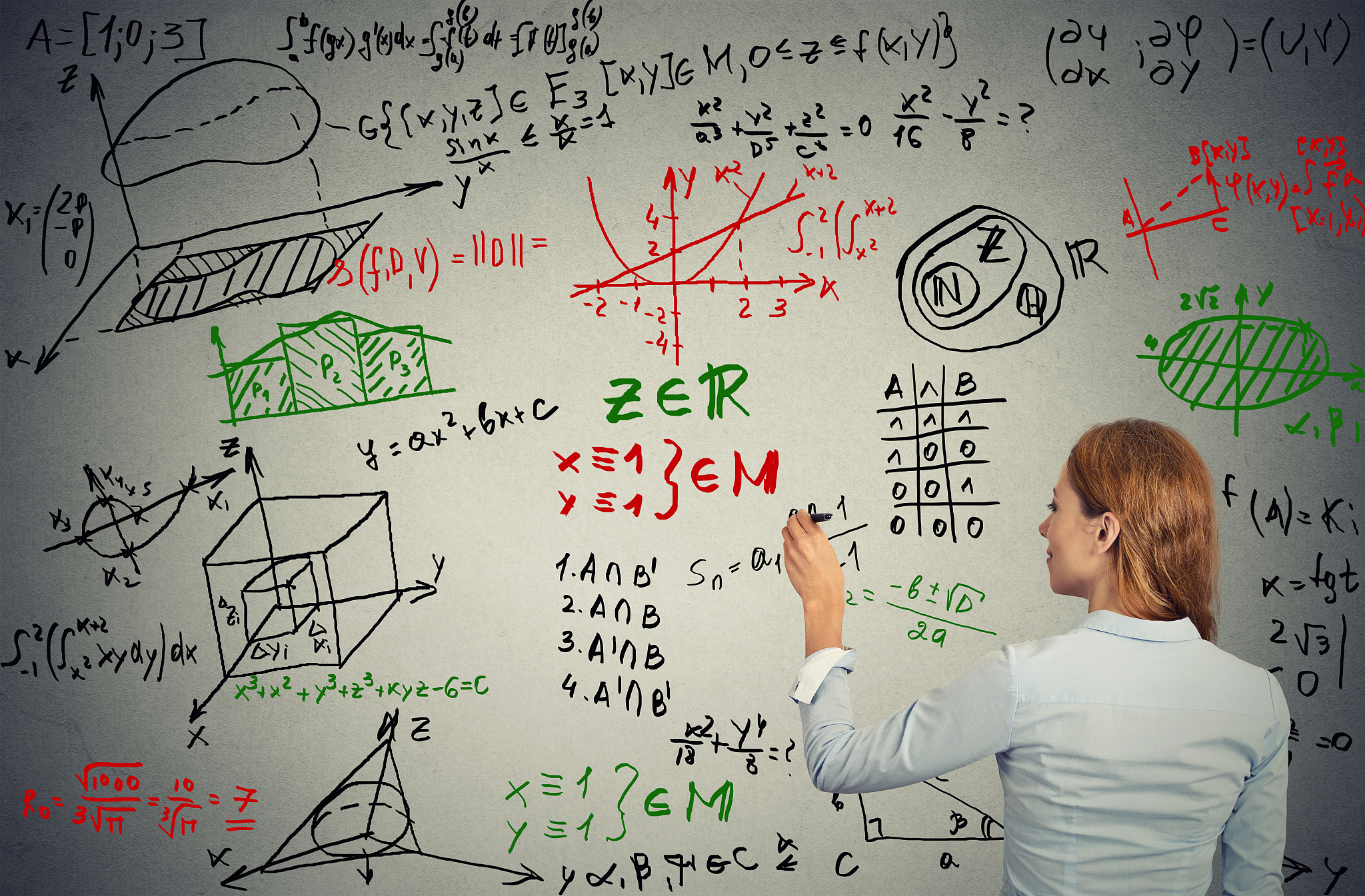 young businesswoman writing on grey wall complicated formulas te