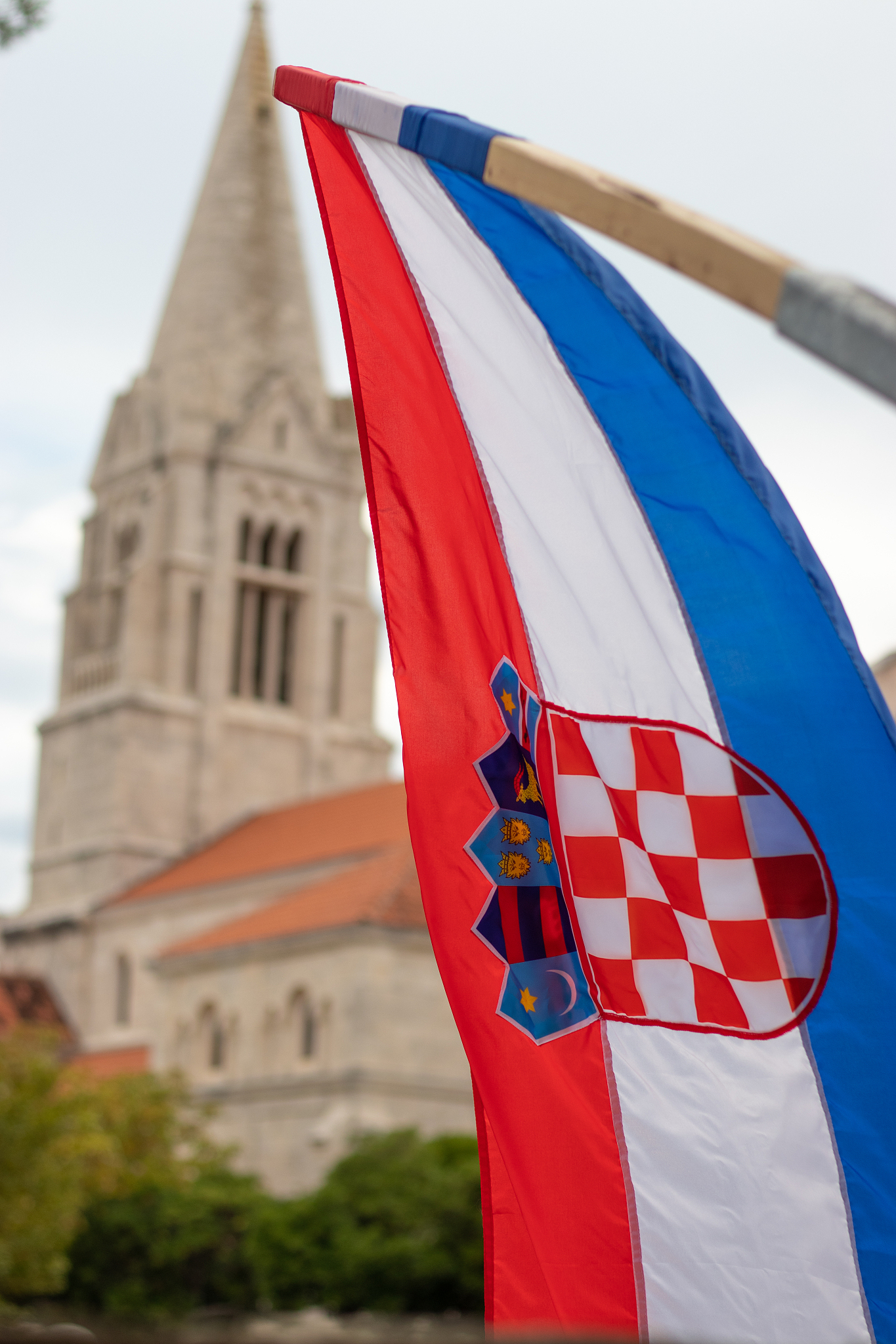 closeup of the croatian flag waving in the wind with the church 