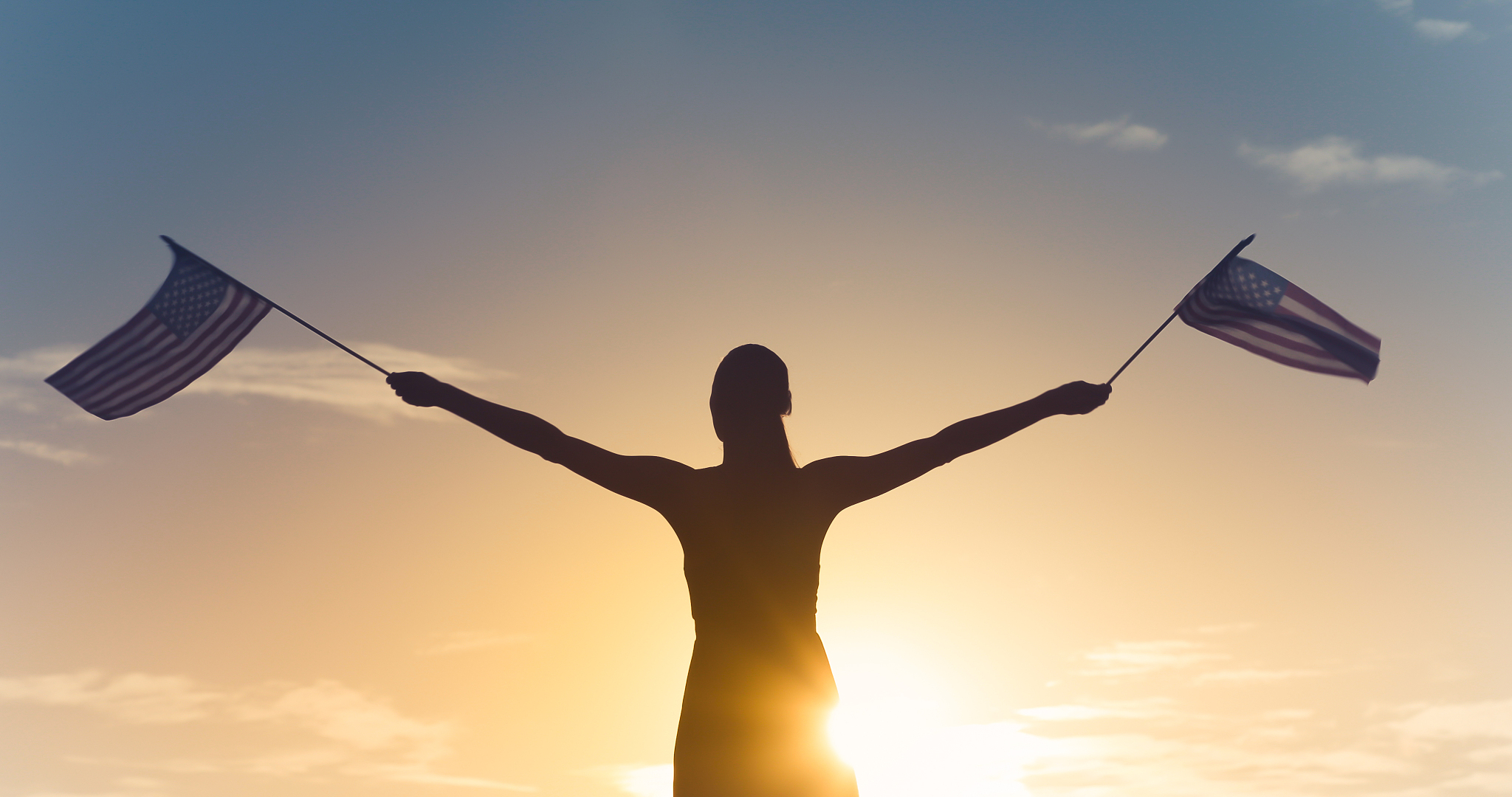 woman waving with american flag in the air.