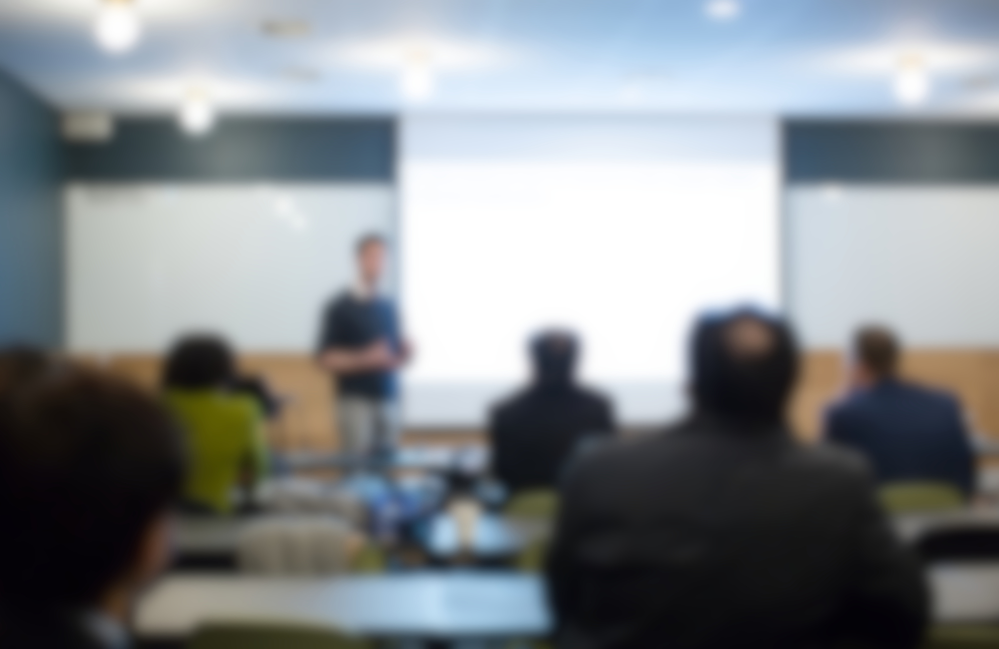 blurred speaker gives public presentation talk during conference