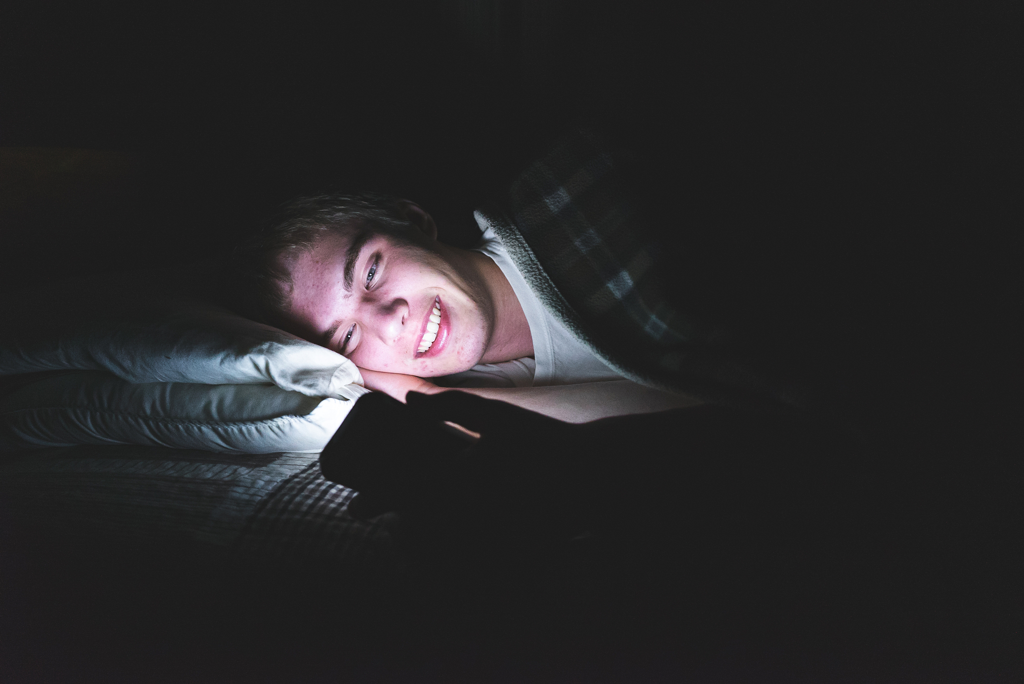 excited teenager watching a video in the dark.