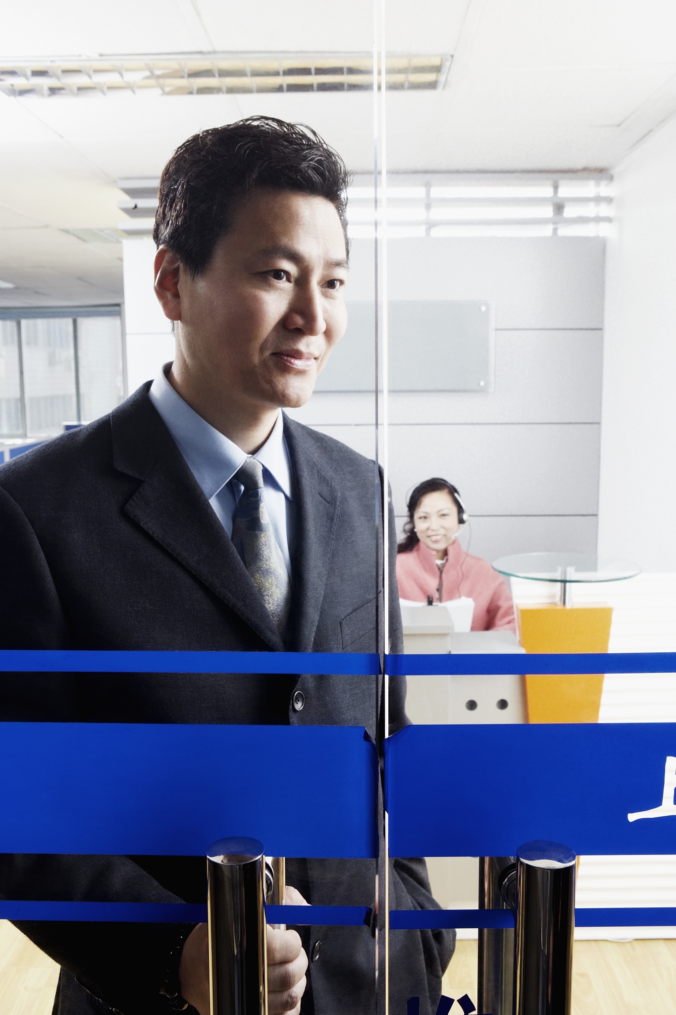 close-up of a businessman standing in an office with a mature wo