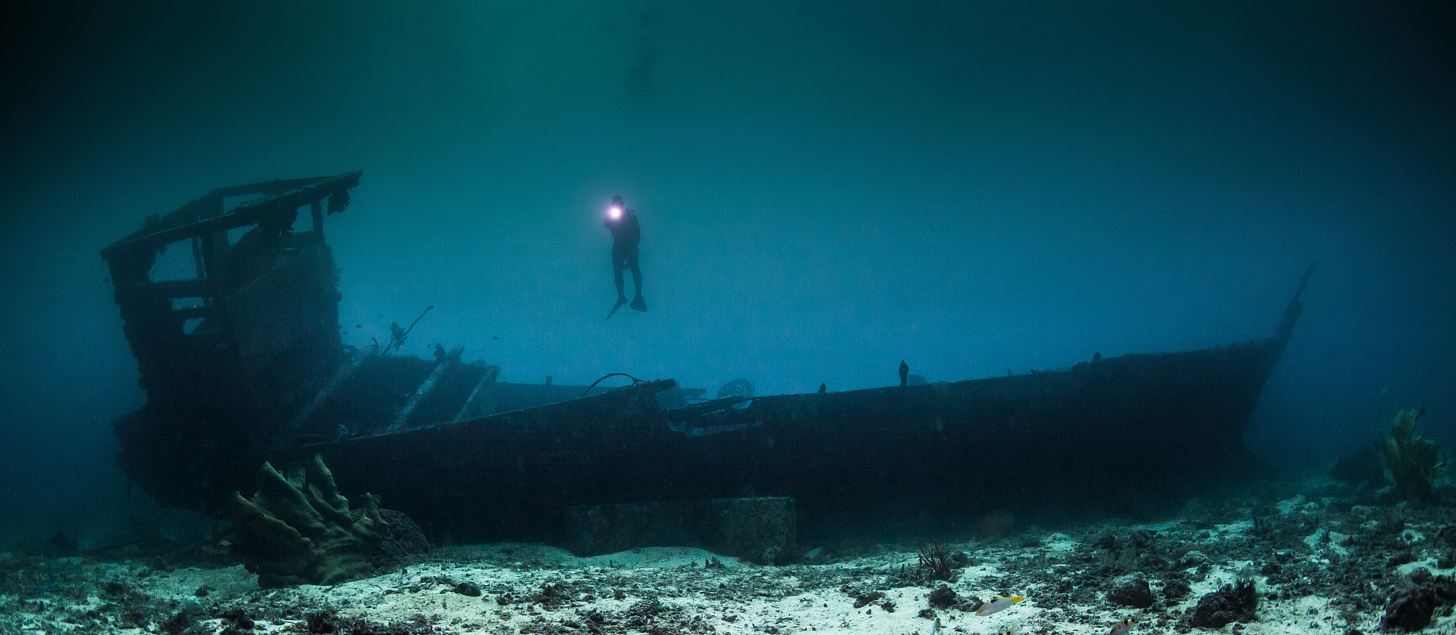 scuba diver explores wreck in undersea