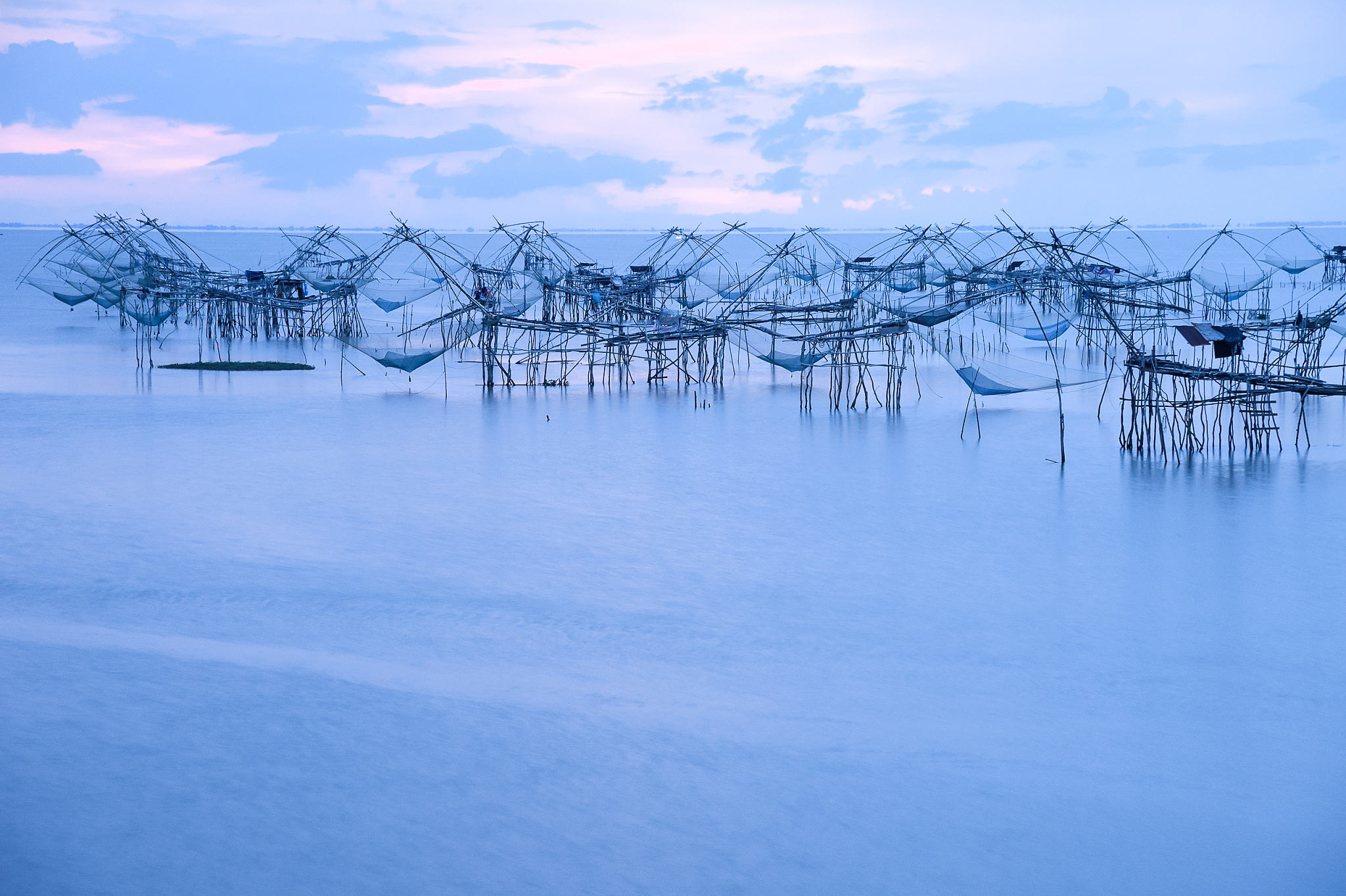 silhouette picture reflection of square dip fishing traps in the