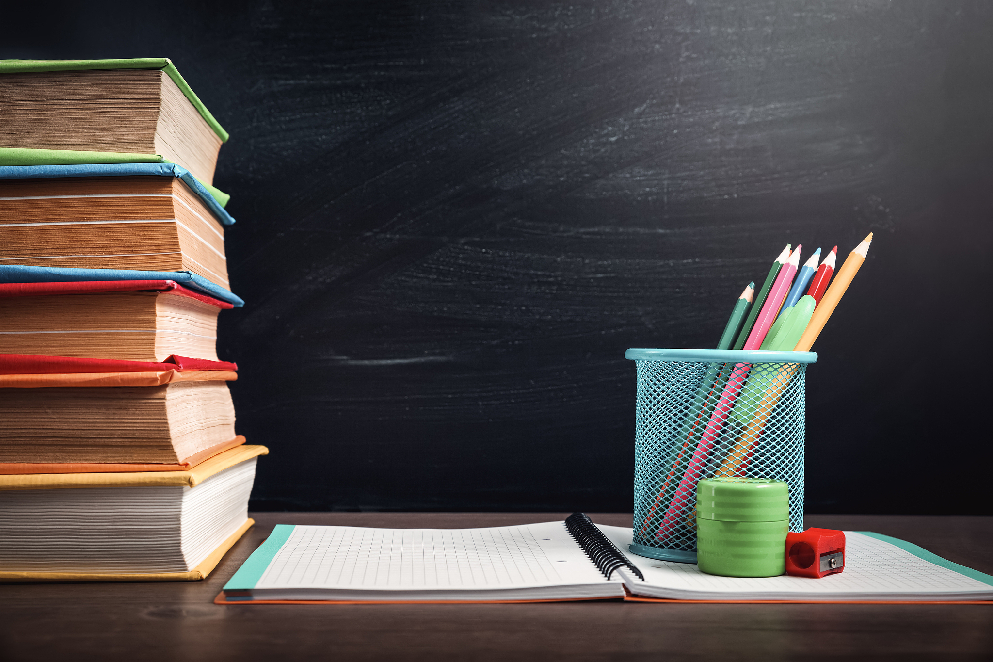 school accessories on the table with blackboard background