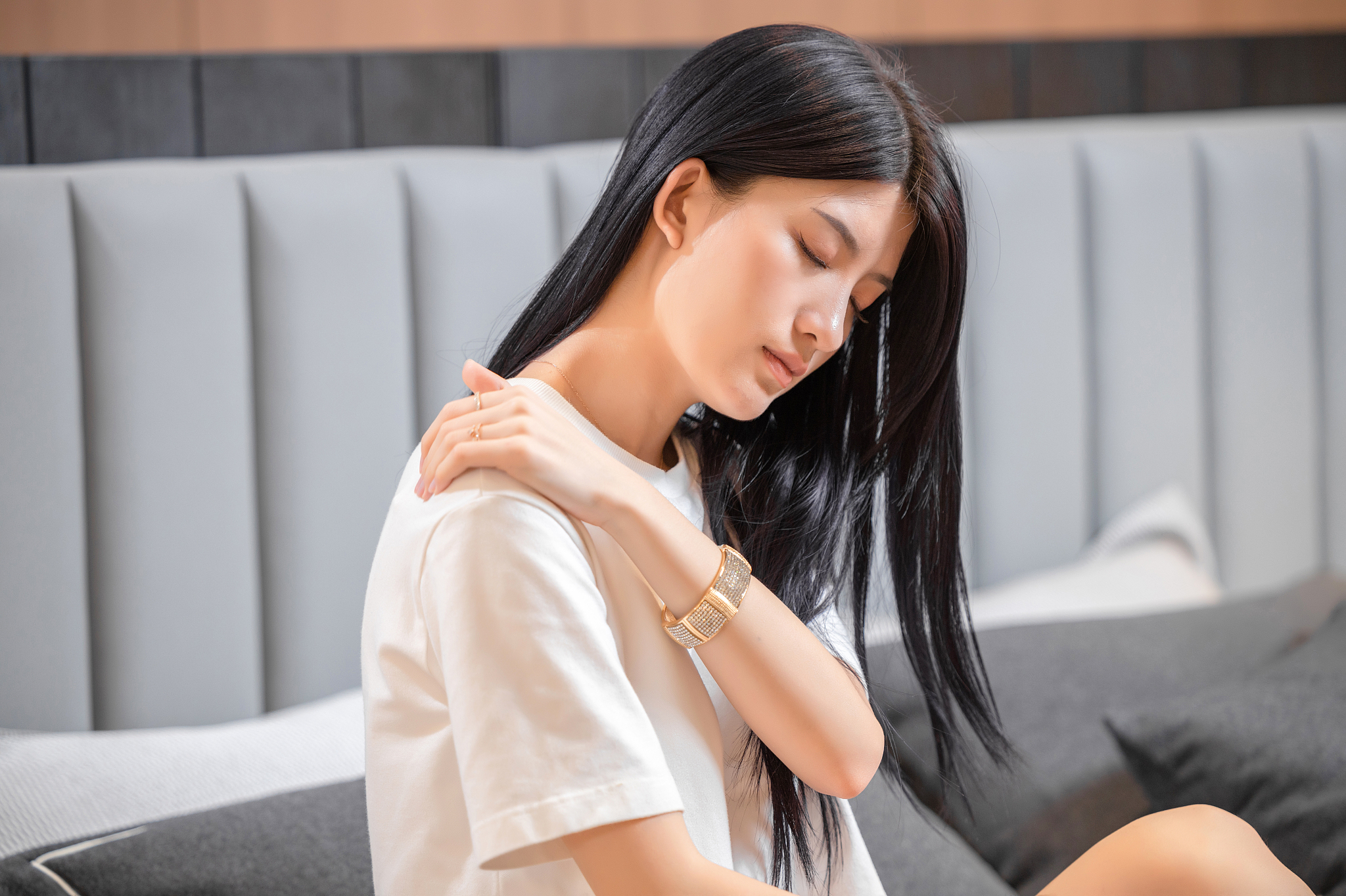 坐在床上,<strong>感觉</strong>肩膀疼痛的女孩