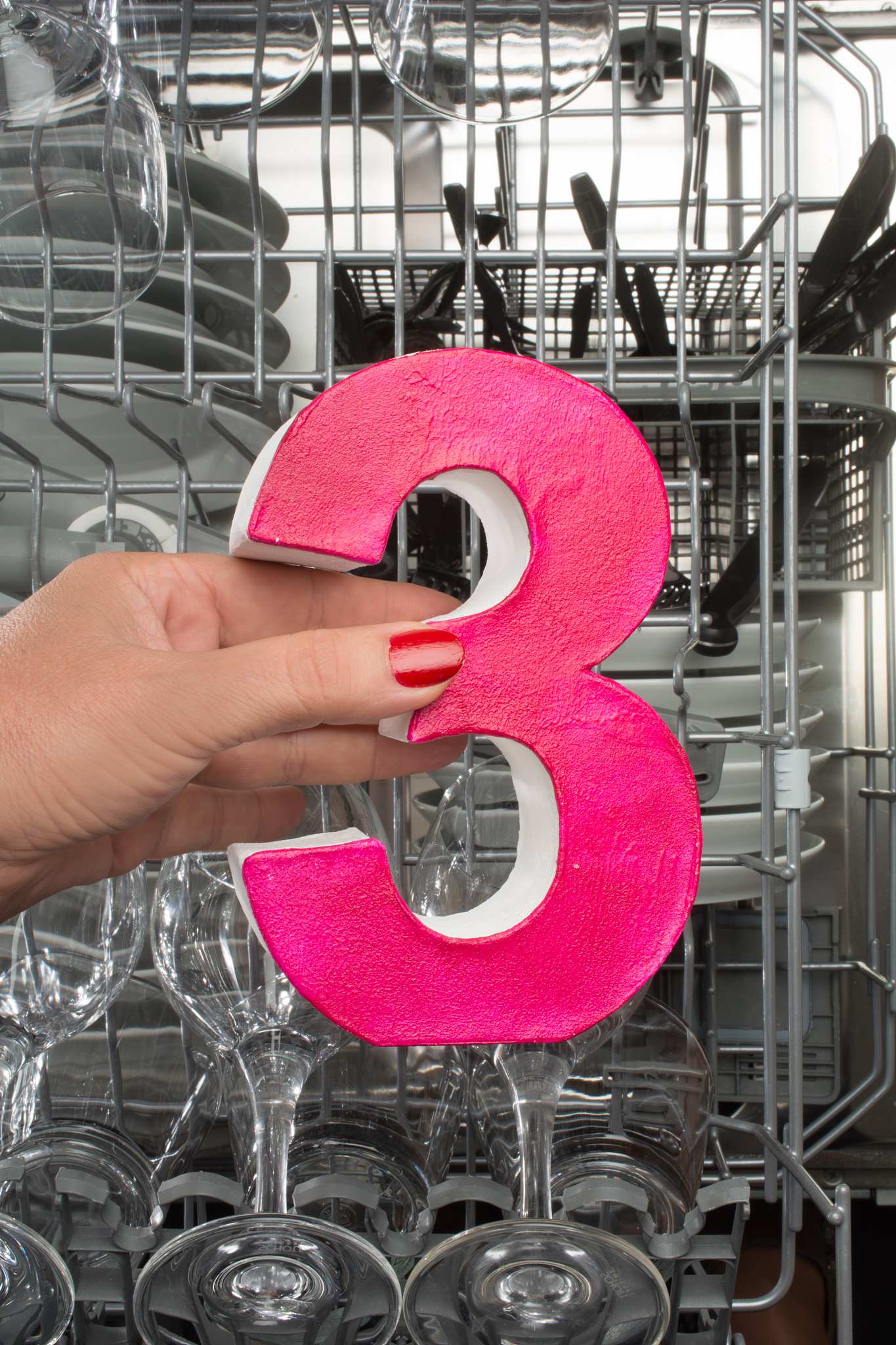 woman holding a number three in a dishwasher