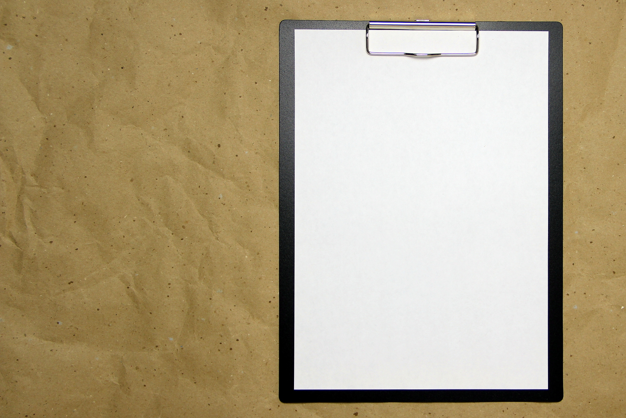 a tablet with a white sheet of a4 format on a beige craft paper