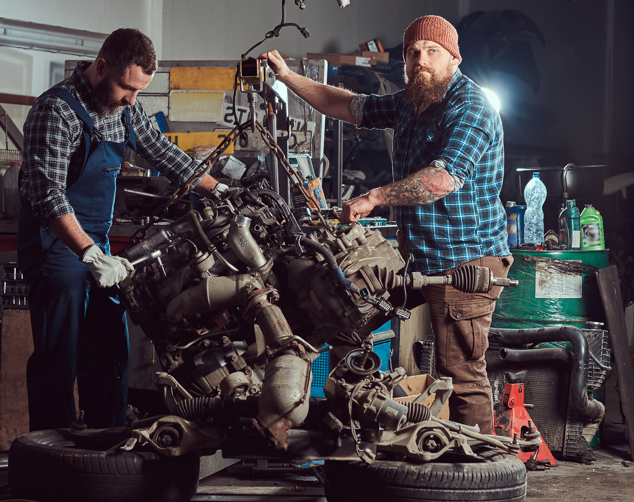 two bearded mechanics specialist repairs the car engine which is