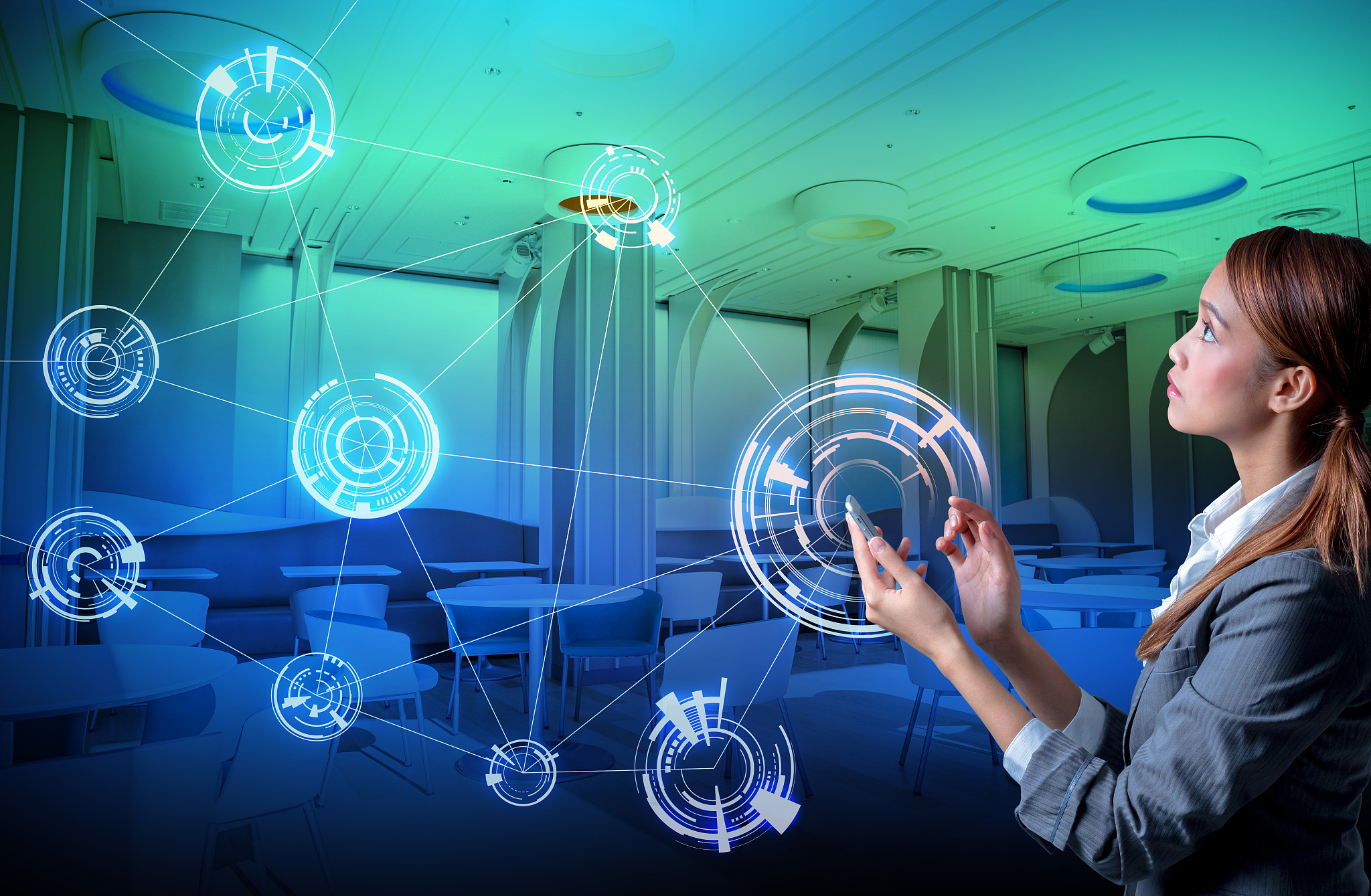 young woman holding smart phone and modern room interior, wirele