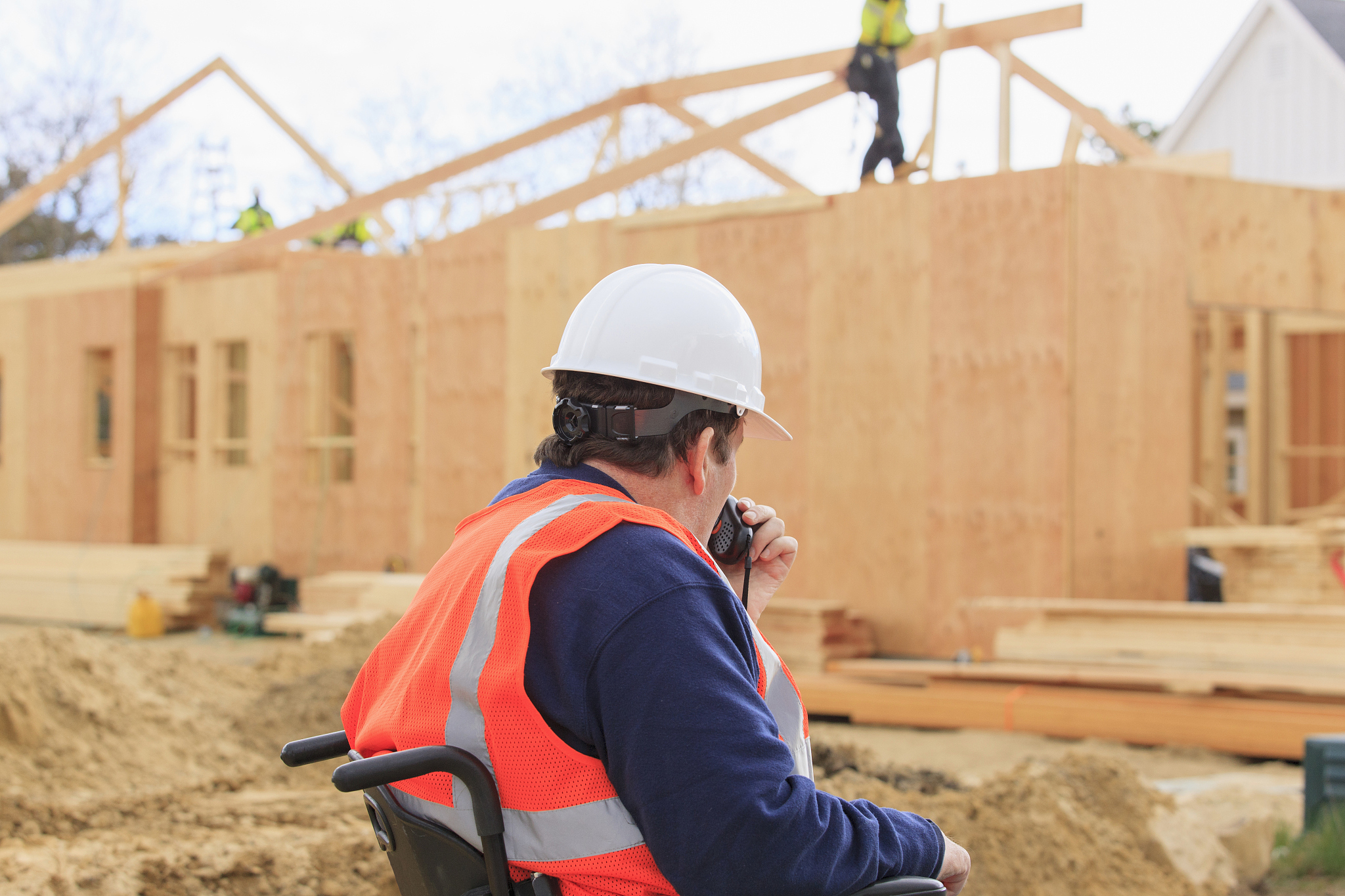 construction engineer with spinal cord injury talking on radio a
