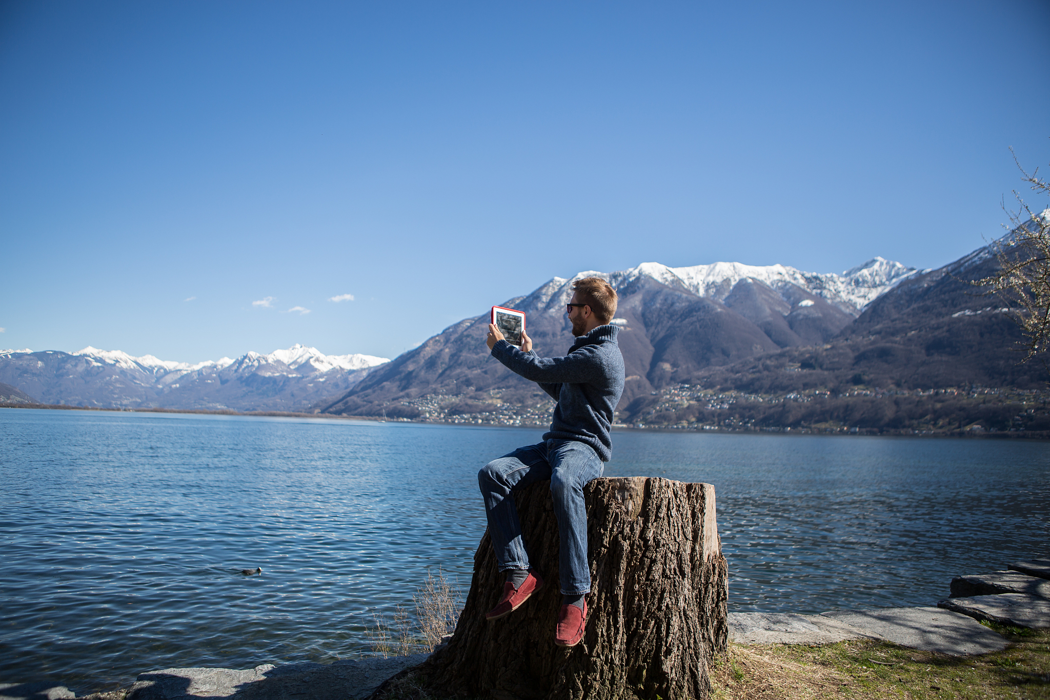 man takes picture of nature with digital tablet