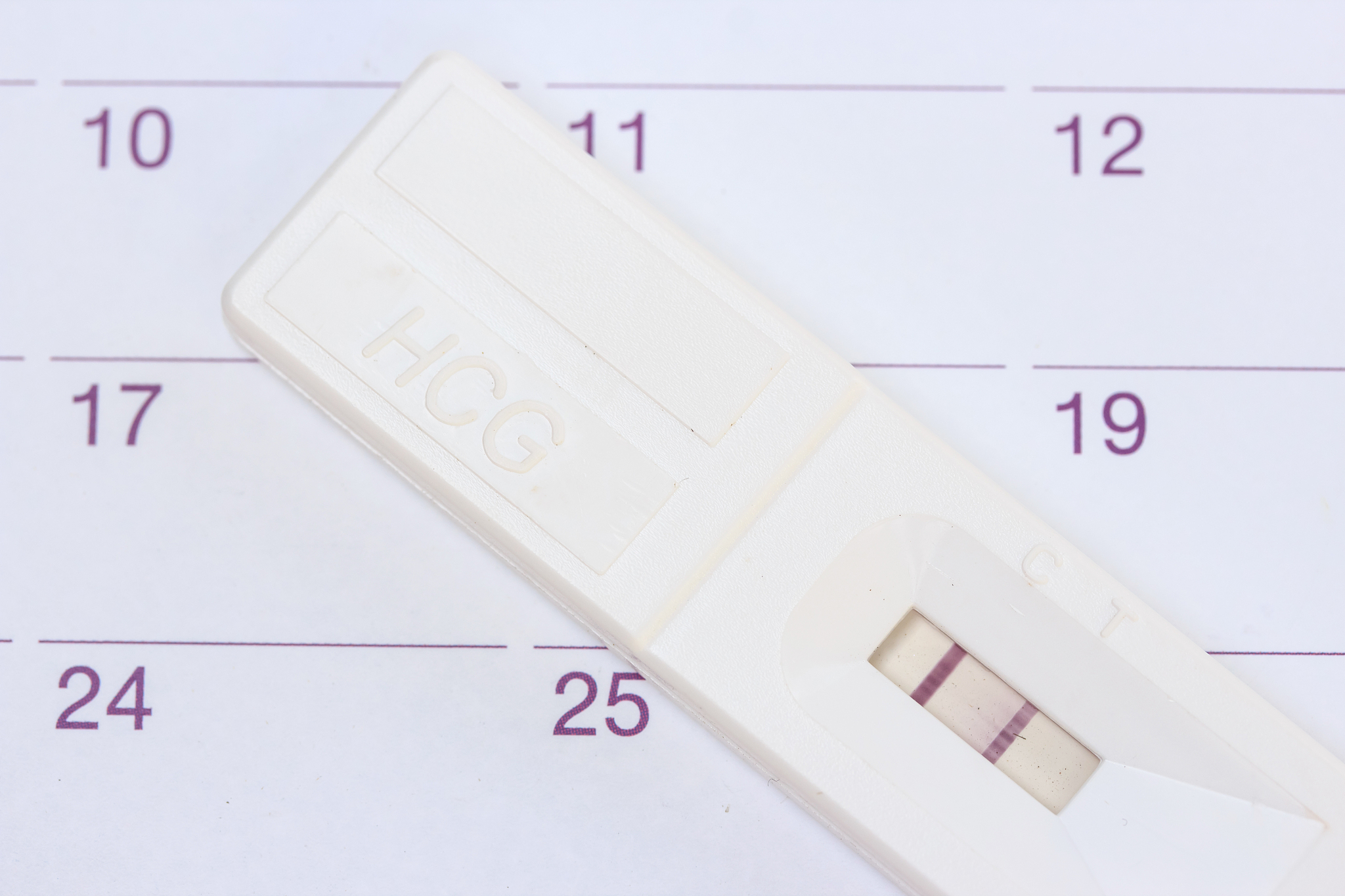 pregnancy test on calendar background.