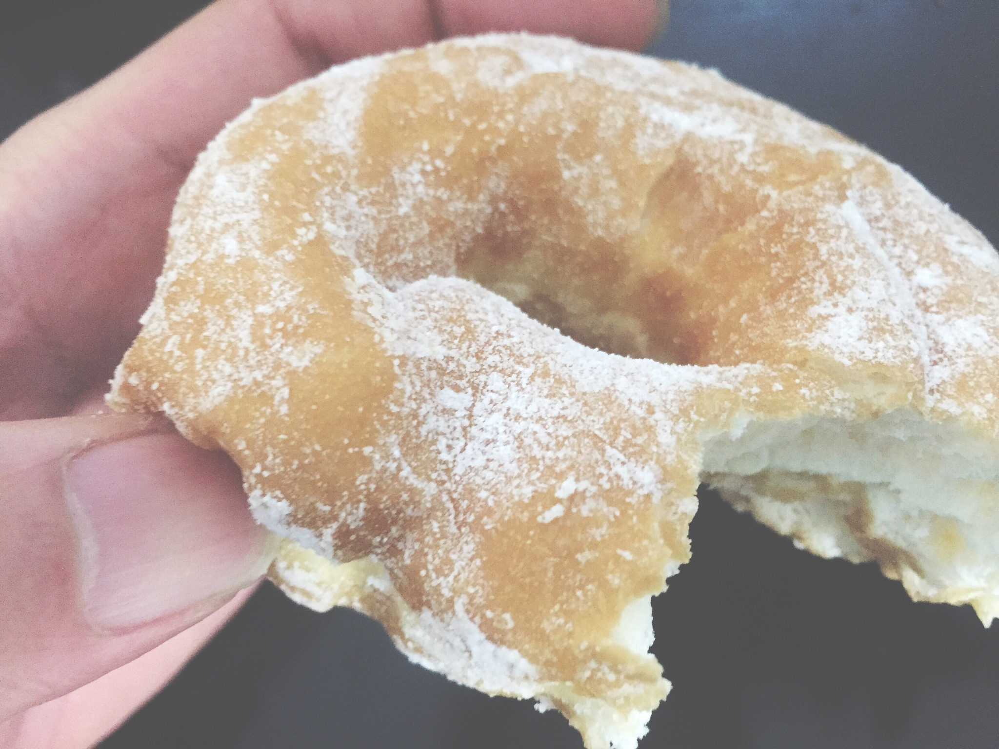 cropped imaged of person holding donut