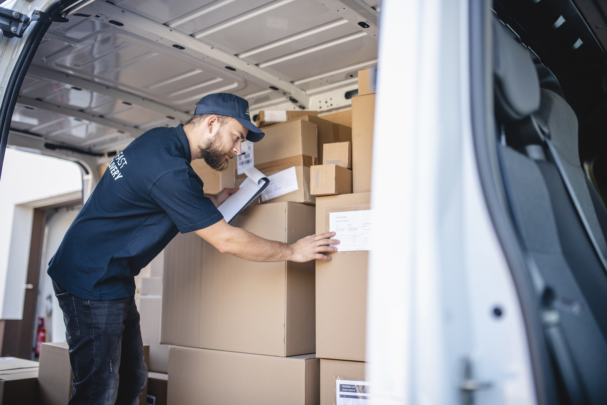 side door view inside delivery van filled with packages